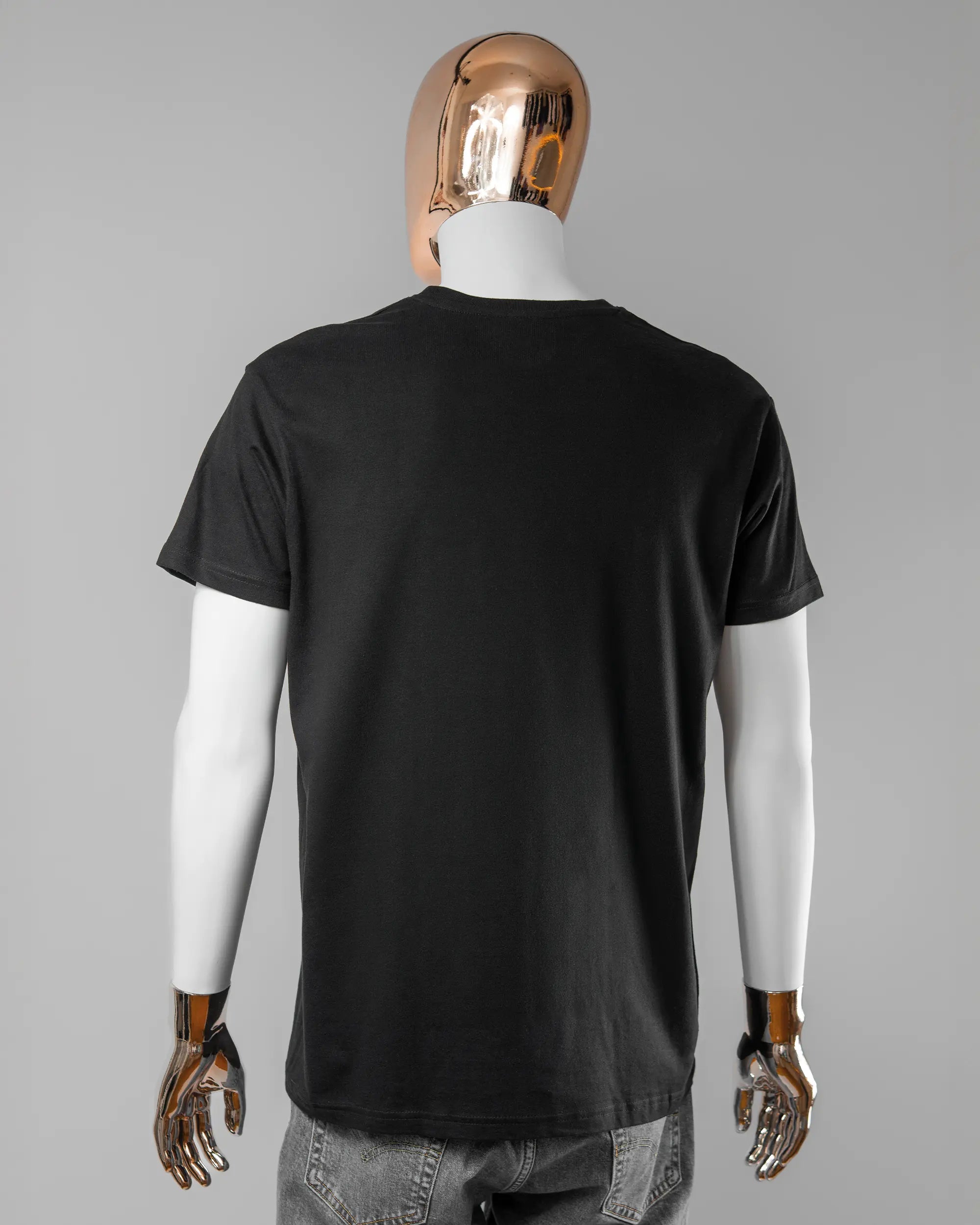 Rückseite des Basic Unisex T-Shirt Soft von Maondo ohne Motiv in der Farbe Black und in der Größe L getragen von einer maskulinen Puppe