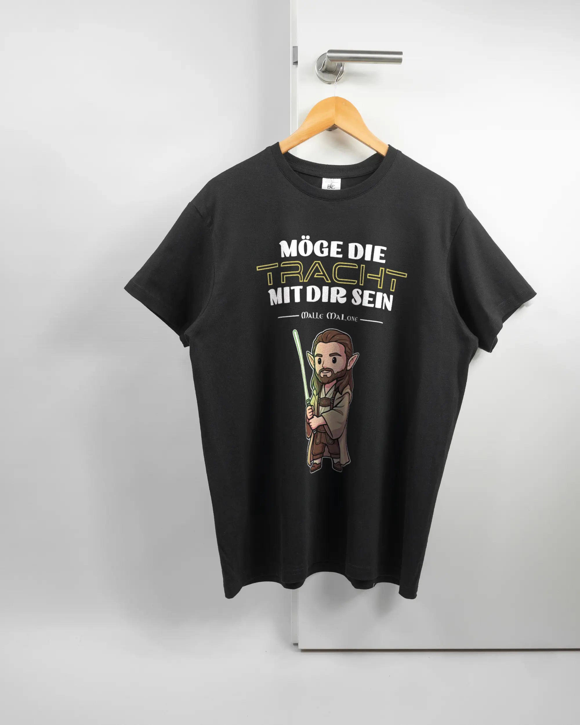 Vorderseite des Basic Unisex T-Shirt Soft von Maondo mit dem Design Tracht mit dir in der Farbe Black und in der Größe L auf einem Bügel an der Türklinke aufgehängt