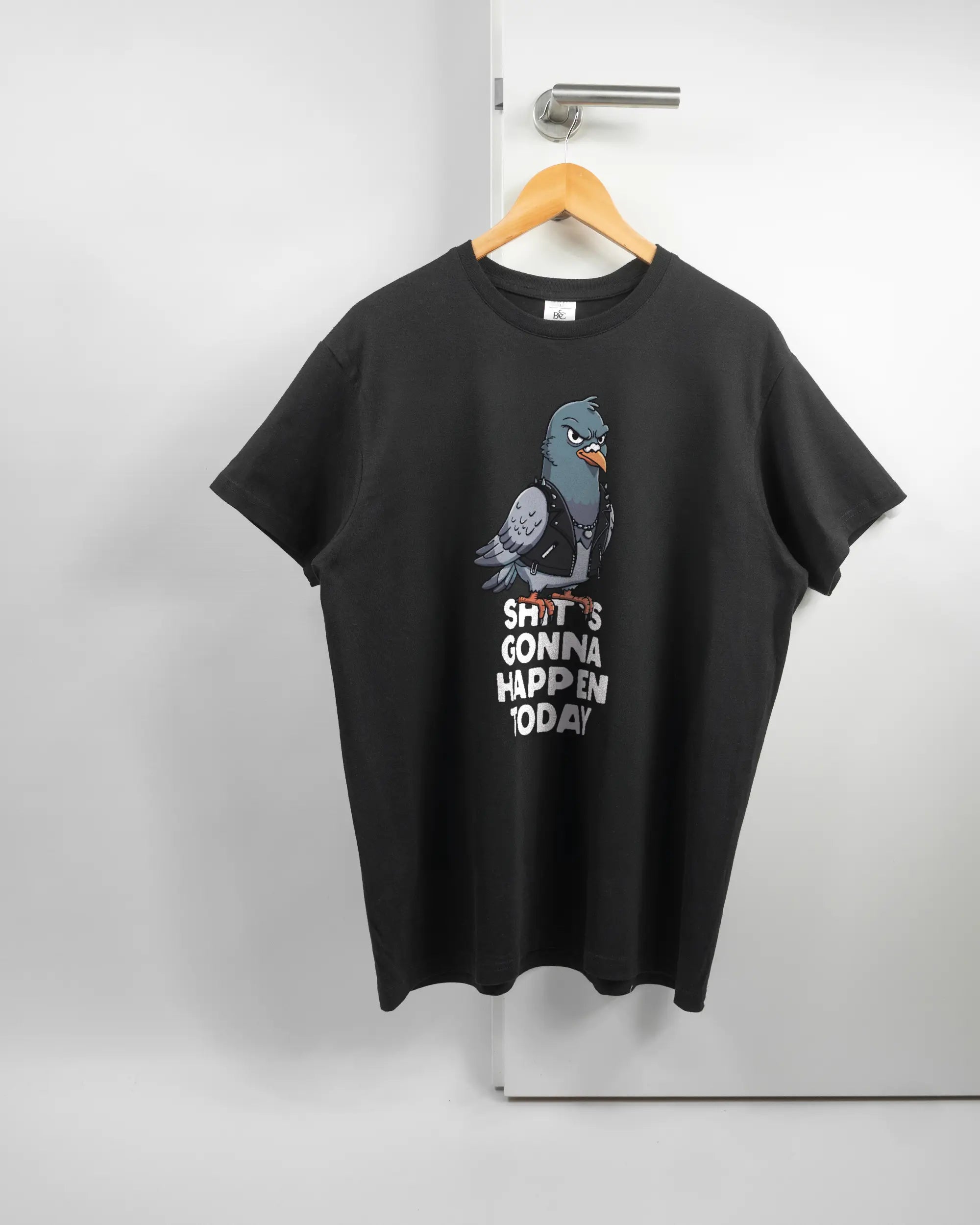 Vorderseite des Basic Unisex T-Shirt Soft von Maondo mit dem Design Pigeon Pun in der Farbe Black und in der Größe L auf einem Bügel an der Türklinke aufgehängt
