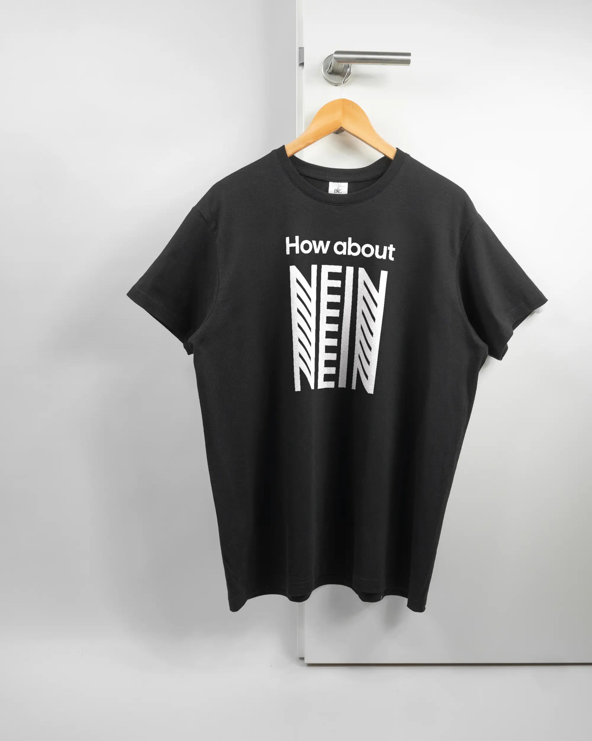Vorderseite des Basic Unisex T-Shirt Soft von Maondo mit dem Design How about nein in der Farbe Black und in der Größe L auf einem Bügel an der Türklinke aufgehängt