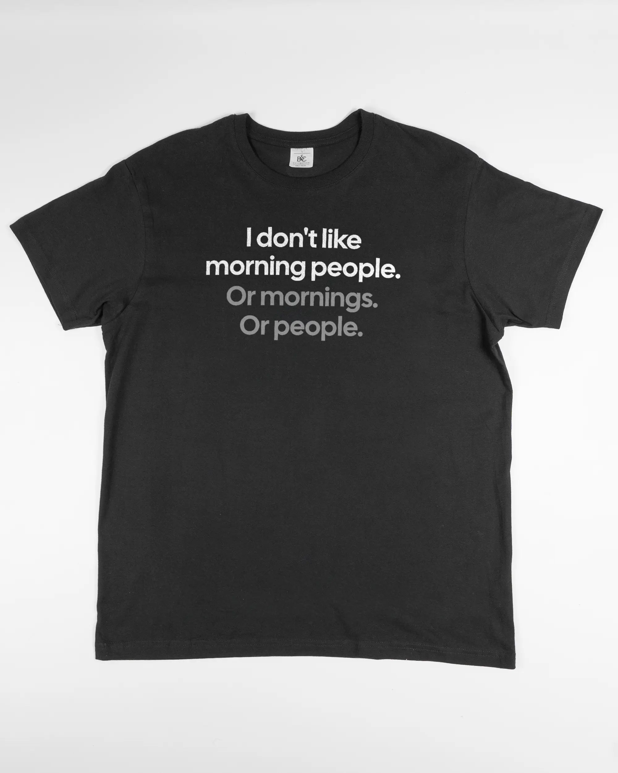 Vorderseite des Basic Unisex T-Shirt Soft von Maondo mit dem Design Morning Person in der Farbe Black und in der Größe L flach auf den Boden gelegt