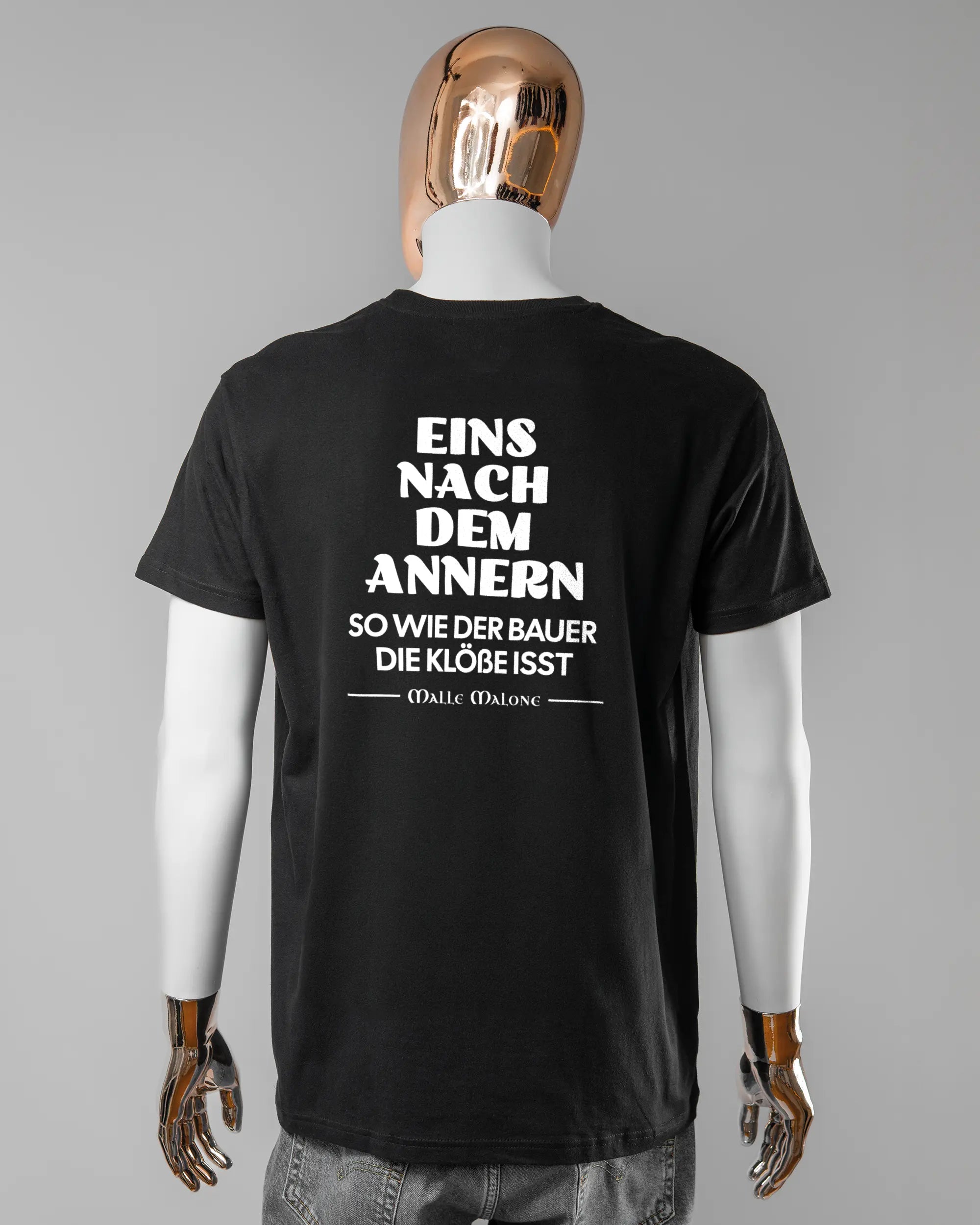 Rückseite des Basic Unisex T-Shirt Soft von Maondo mit dem Design Eins nach dem Annern in der Farbe Black und in der Größe L getragen von einer maskulinen Puppe