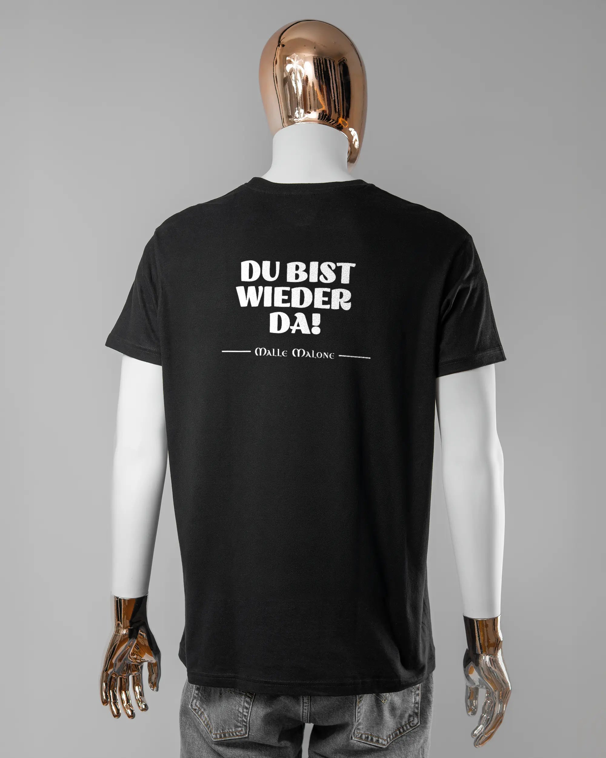 Rückseite des Basic Unisex T-Shirt Soft von Maondo mit dem Design Wieder da in der Farbe Black und in der Größe L getragen von einer maskulinen Puppe