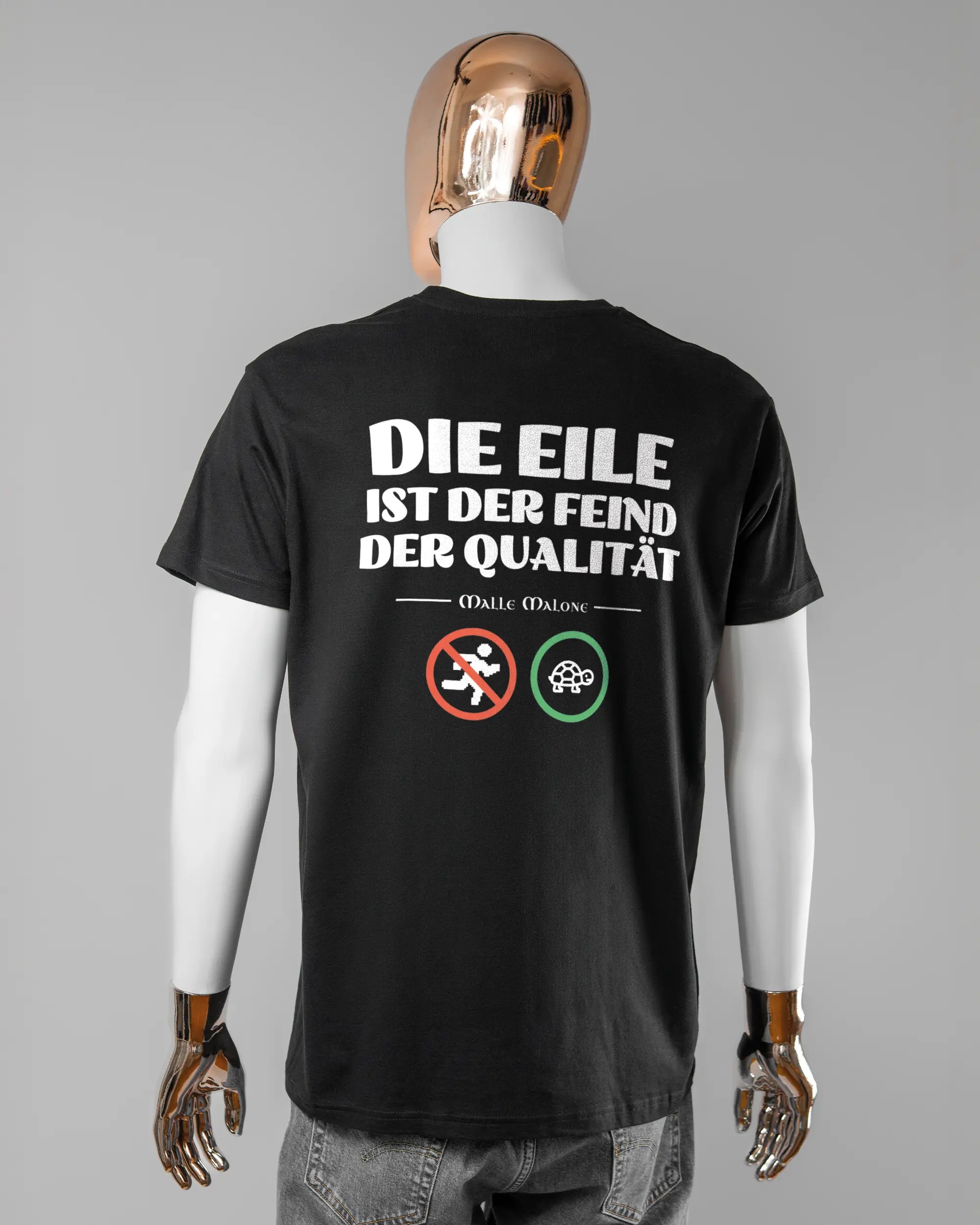 Rückseite des Basic Unisex T-Shirt Soft von Maondo mit dem Design Keine Eile in der Farbe Black und in der Größe L getragen von einer maskulinen Puppe