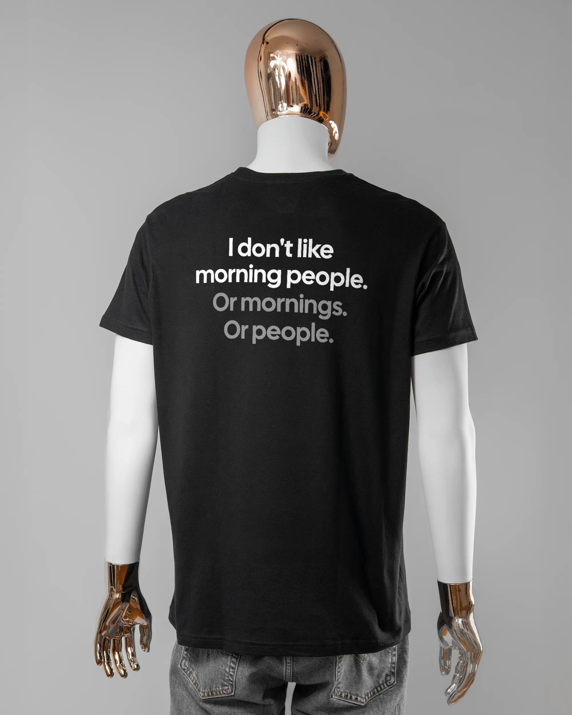 Rückseite des Basic Unisex T-Shirt Soft von Maondo mit dem Design Morning Person in der Farbe Black und in der Größe L getragen von einer maskulinen Puppe