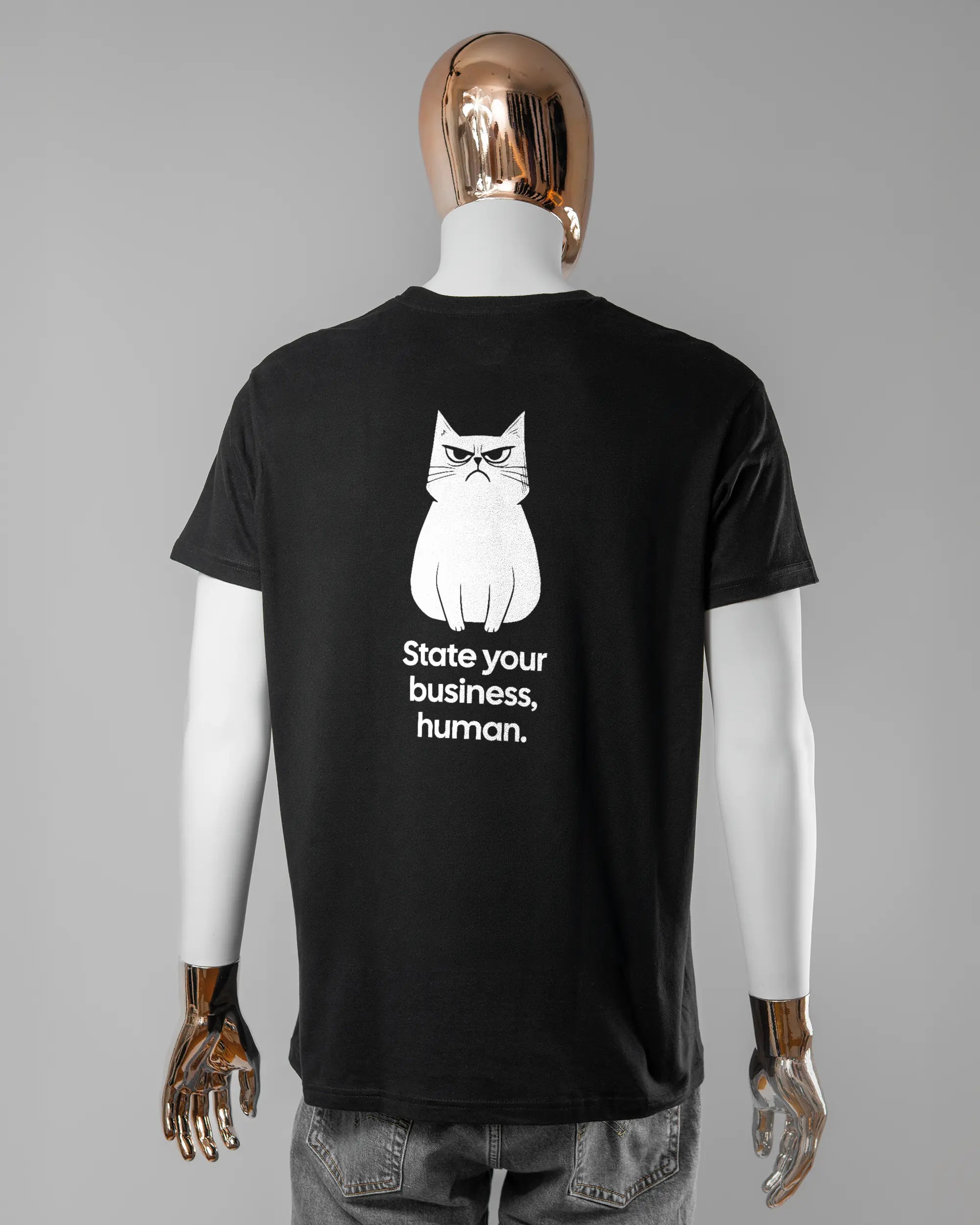 Rückseite des Basic Unisex T-Shirt Soft von Maondo mit dem Design Grumpy Purr in der Farbe Black und in der Größe L getragen von einer maskulinen Puppe