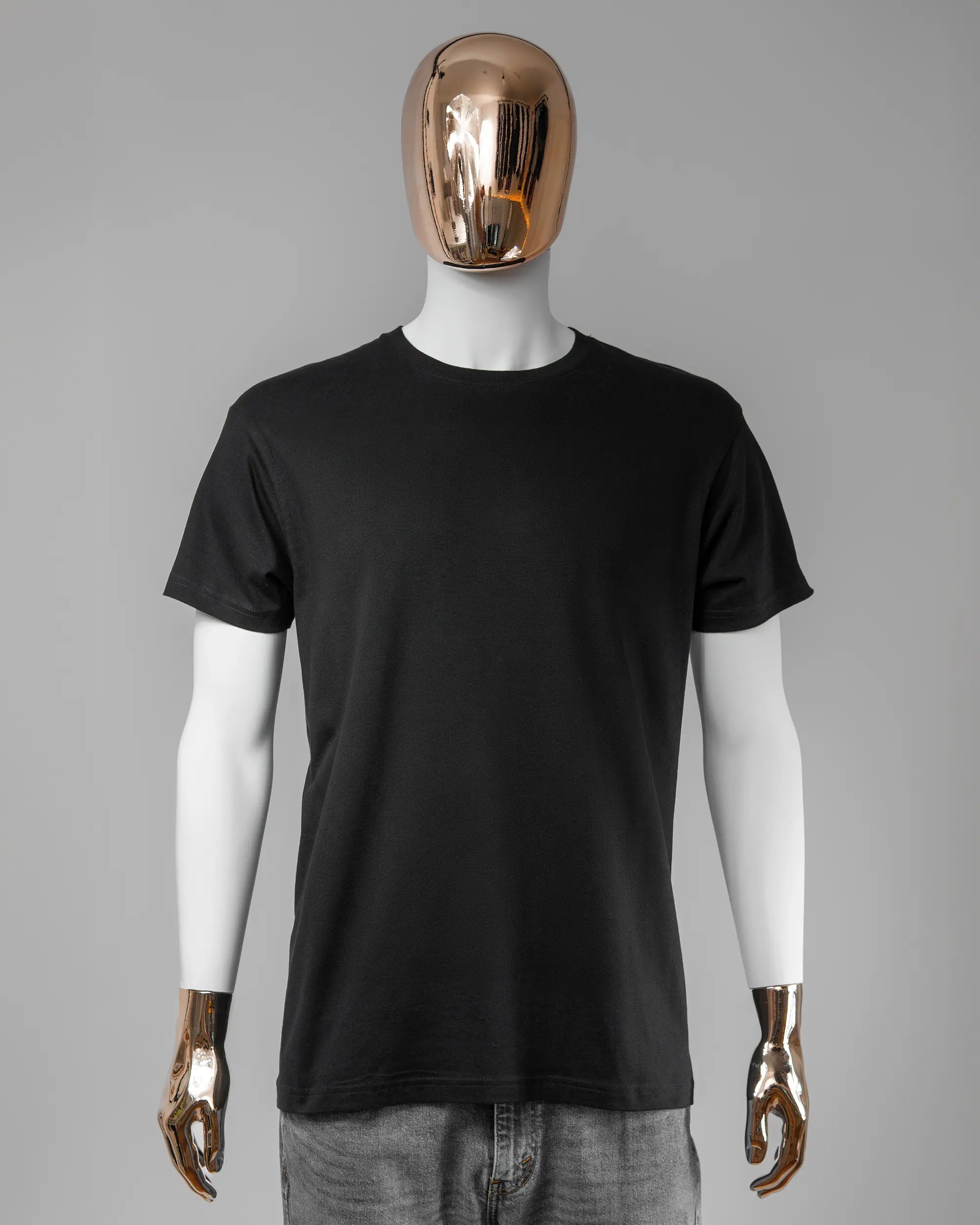 Vorderseite des Basic Unisex T-Shirt Soft von Maondo ohne Motiv in der Farbe Black und in der Größe L getragen von einer maskulinen Puppe