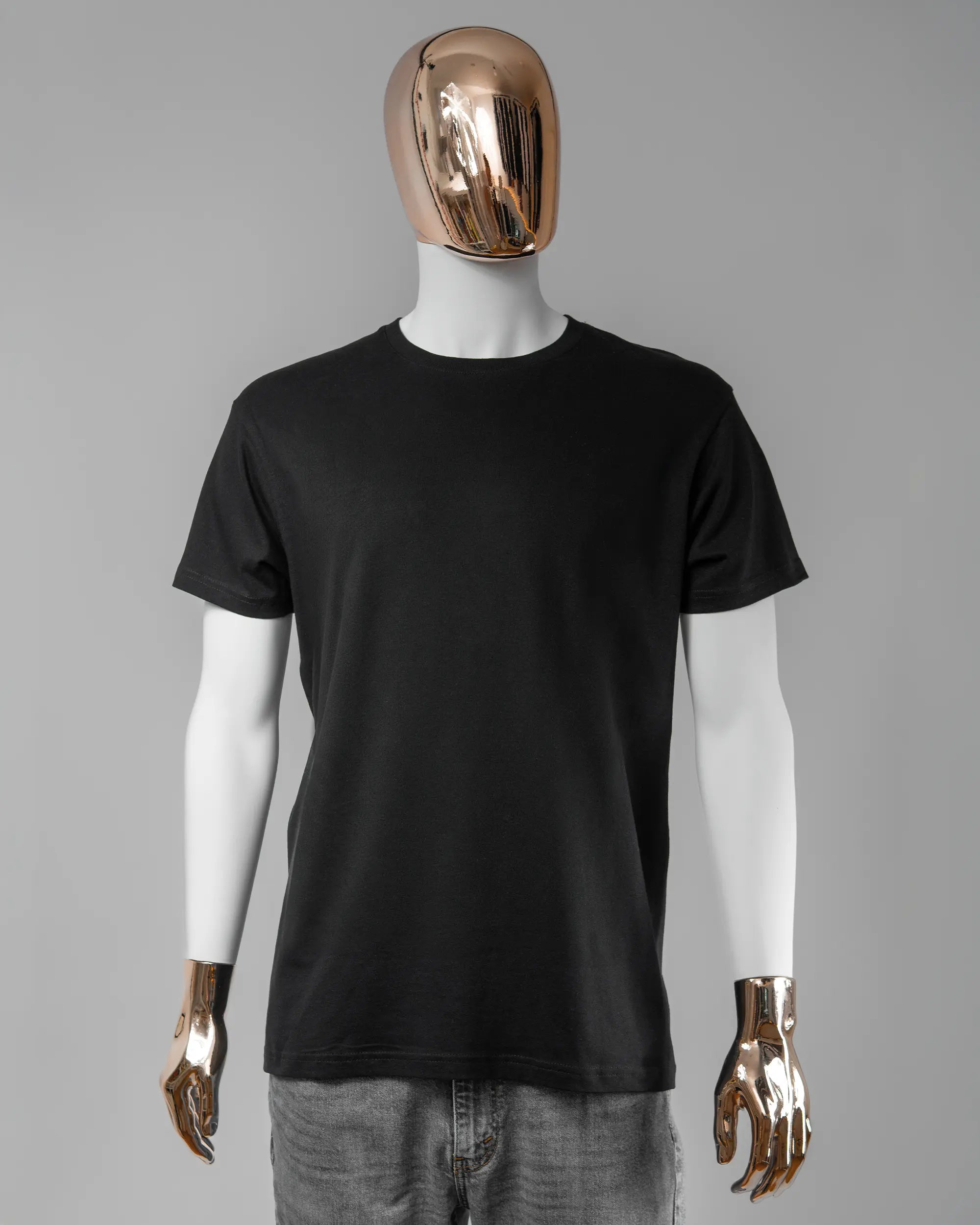 Vorderseite des Basic Unisex T-Shirt Soft von Maondo ohne Motiv in der Farbe Black und in der Größe L getragen von einer maskulinen Puppe