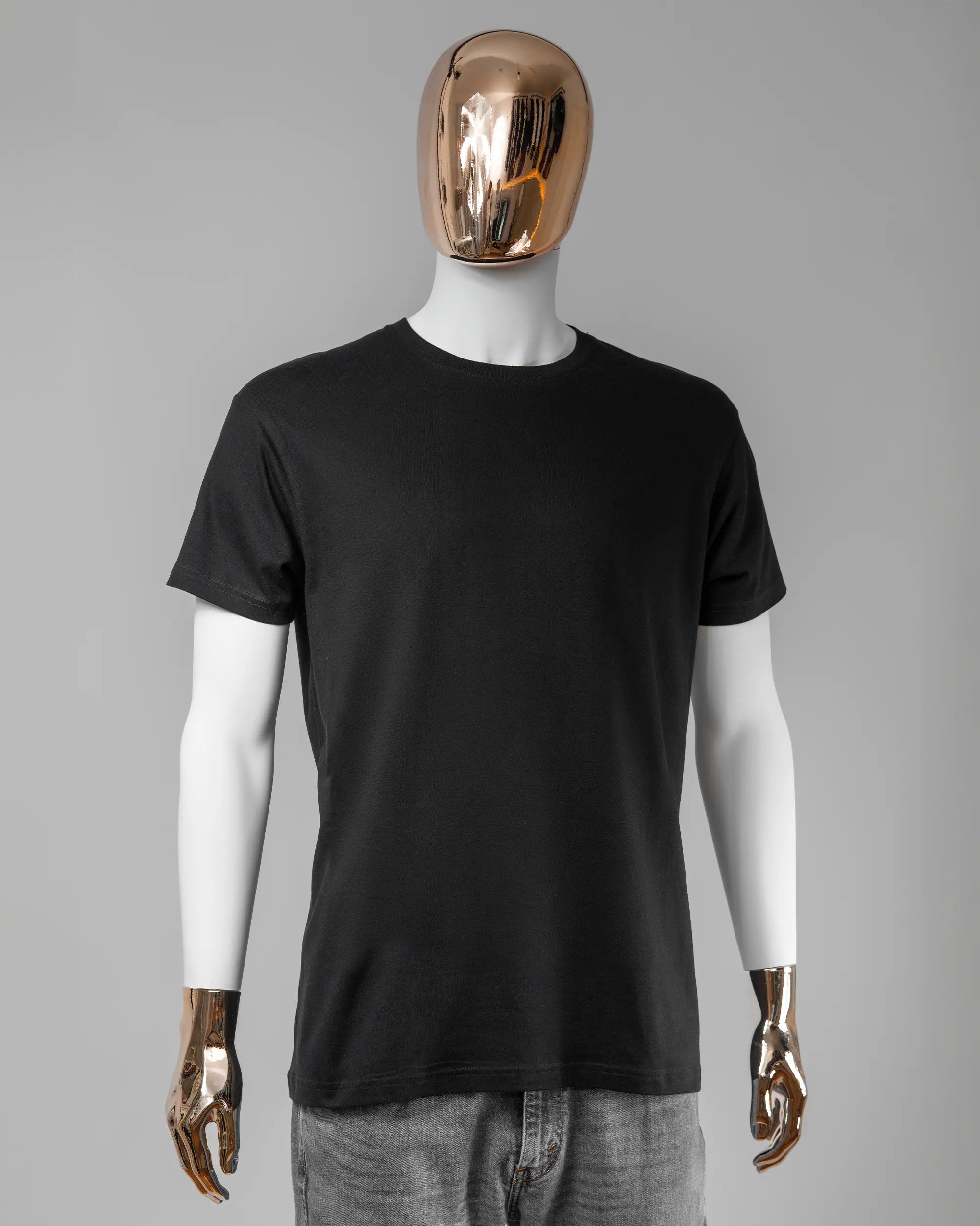 Vorderseite des Basic Unisex T-Shirt Soft von Maondo ohne Motiv in der Farbe Black und in der Größe L getragen von einer maskulinen Puppe