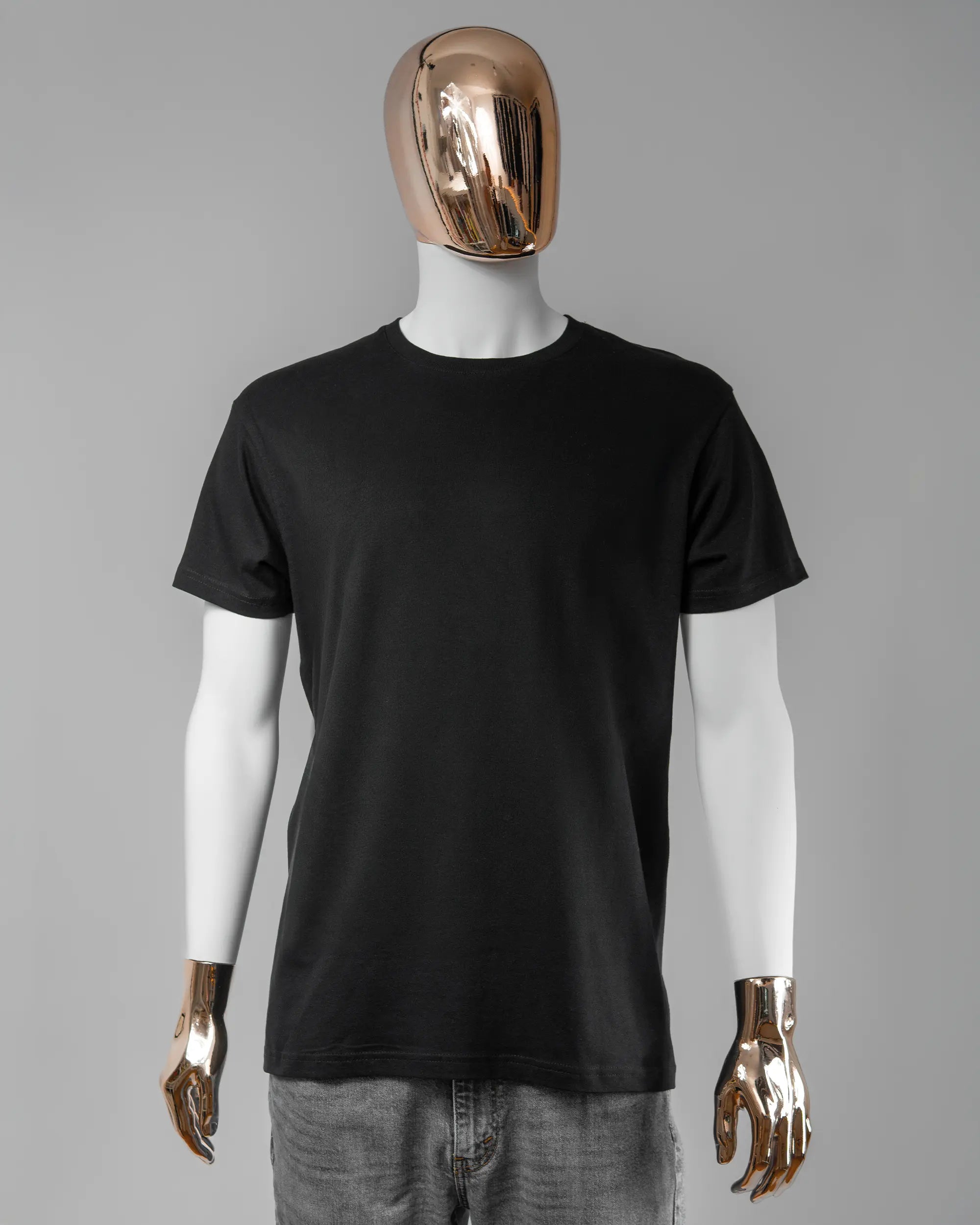 Vorderseite des Basic Unisex T-Shirt Soft von Maondo ohne Motiv in der Farbe Black und in der Größe L getragen von einer maskulinen Puppe