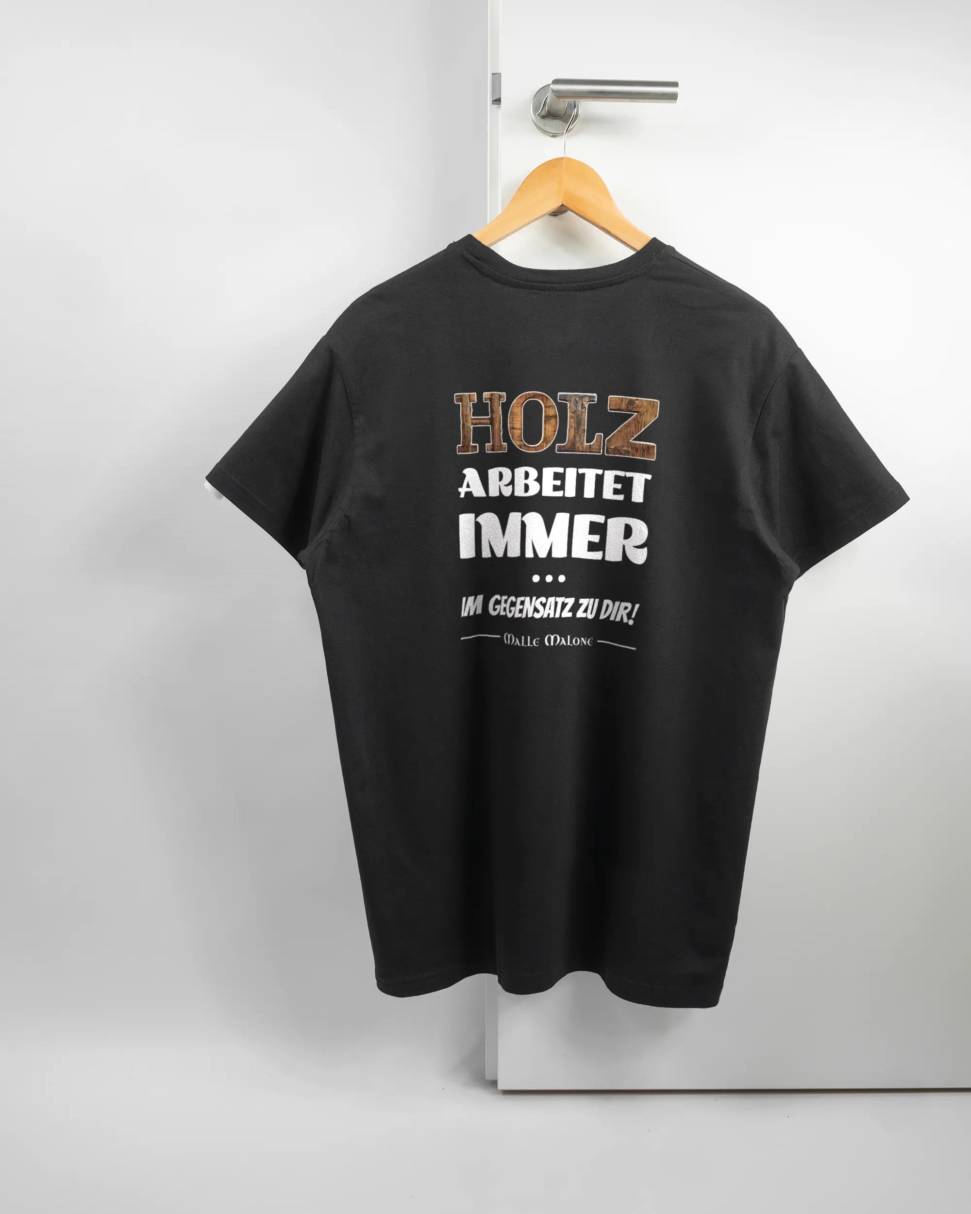 Rückseite des Basic Unisex T-Shirt Soft von Maondo mit dem Design Holzarbeit in der Farbe Black und in der Größe L auf einem Bügel an der Türklinke aufgehängt