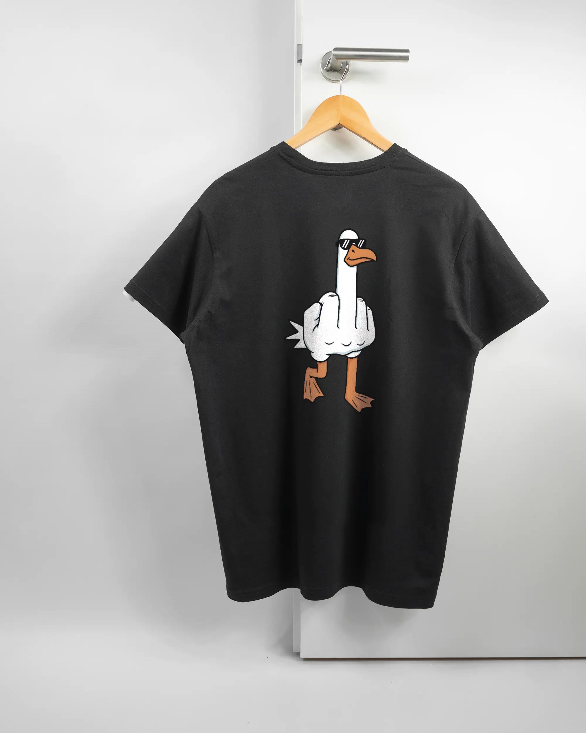 Rückseite des Basic Unisex T-Shirt Soft von Maondo mit dem Design I give a duck in der Farbe Black und in der Größe L auf einem Bügel an der Türklinke aufgehängt