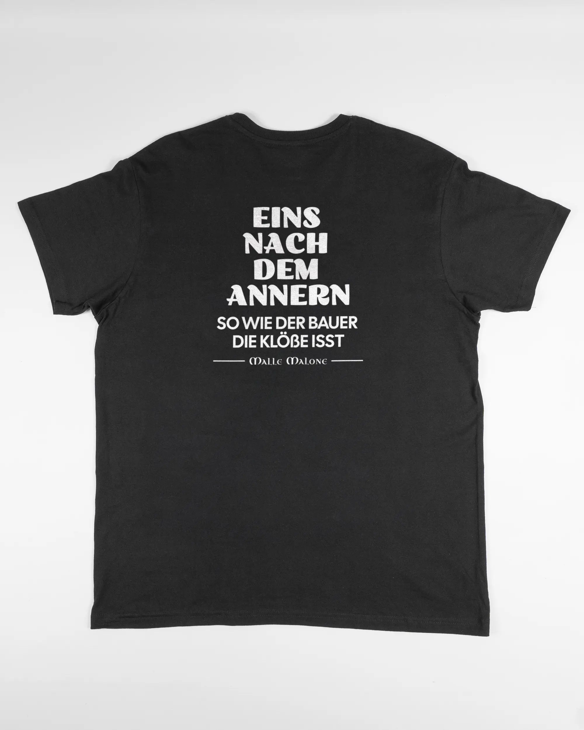 Rückseite des Basic Unisex T-Shirt Soft von Maondo mit dem Design Eins nach dem Annern in der Farbe Black und in der Größe L flach auf den Boden gelegt