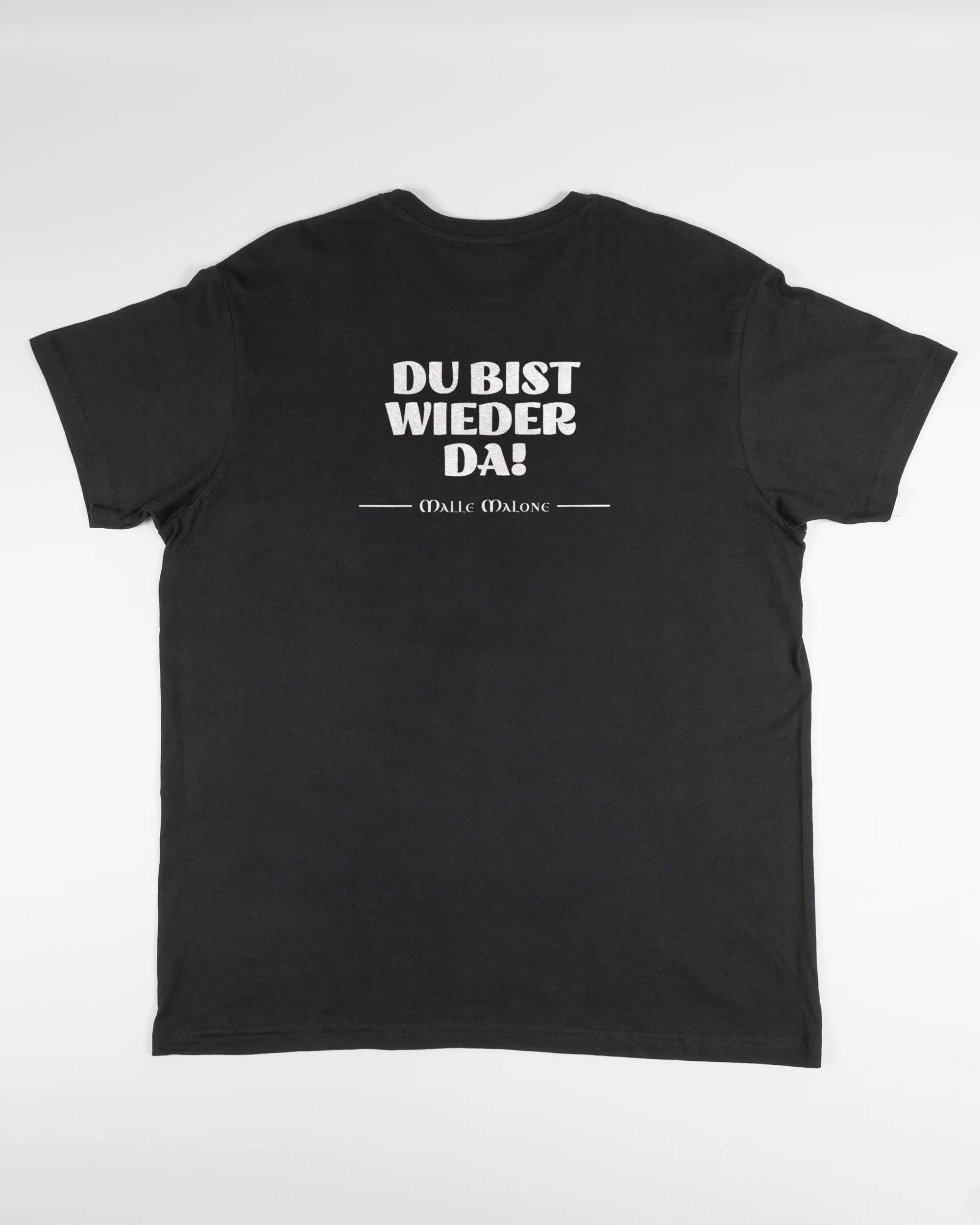 Rückseite des Basic Unisex T-Shirt Soft von Maondo mit dem Design Wieder da in der Farbe Black und in der Größe L flach auf den Boden gelegt