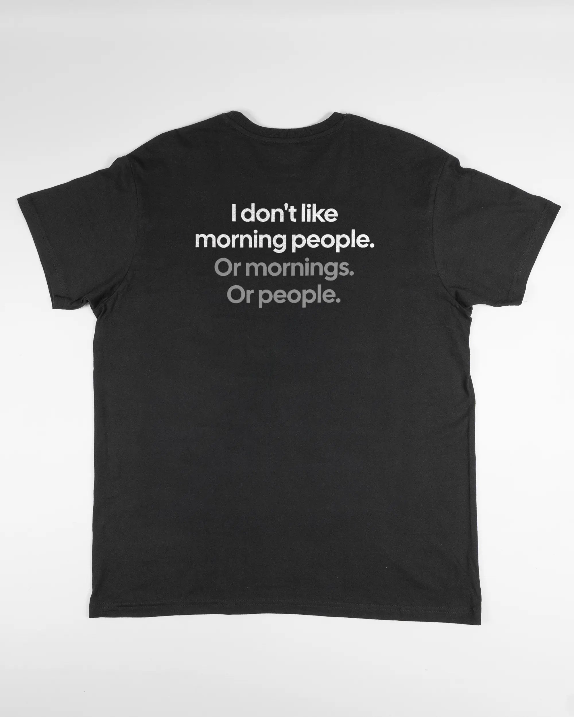 Rückseite des Basic Unisex T-Shirt Soft von Maondo mit dem Design Morning Person in der Farbe Black und in der Größe L flach auf den Boden gelegt