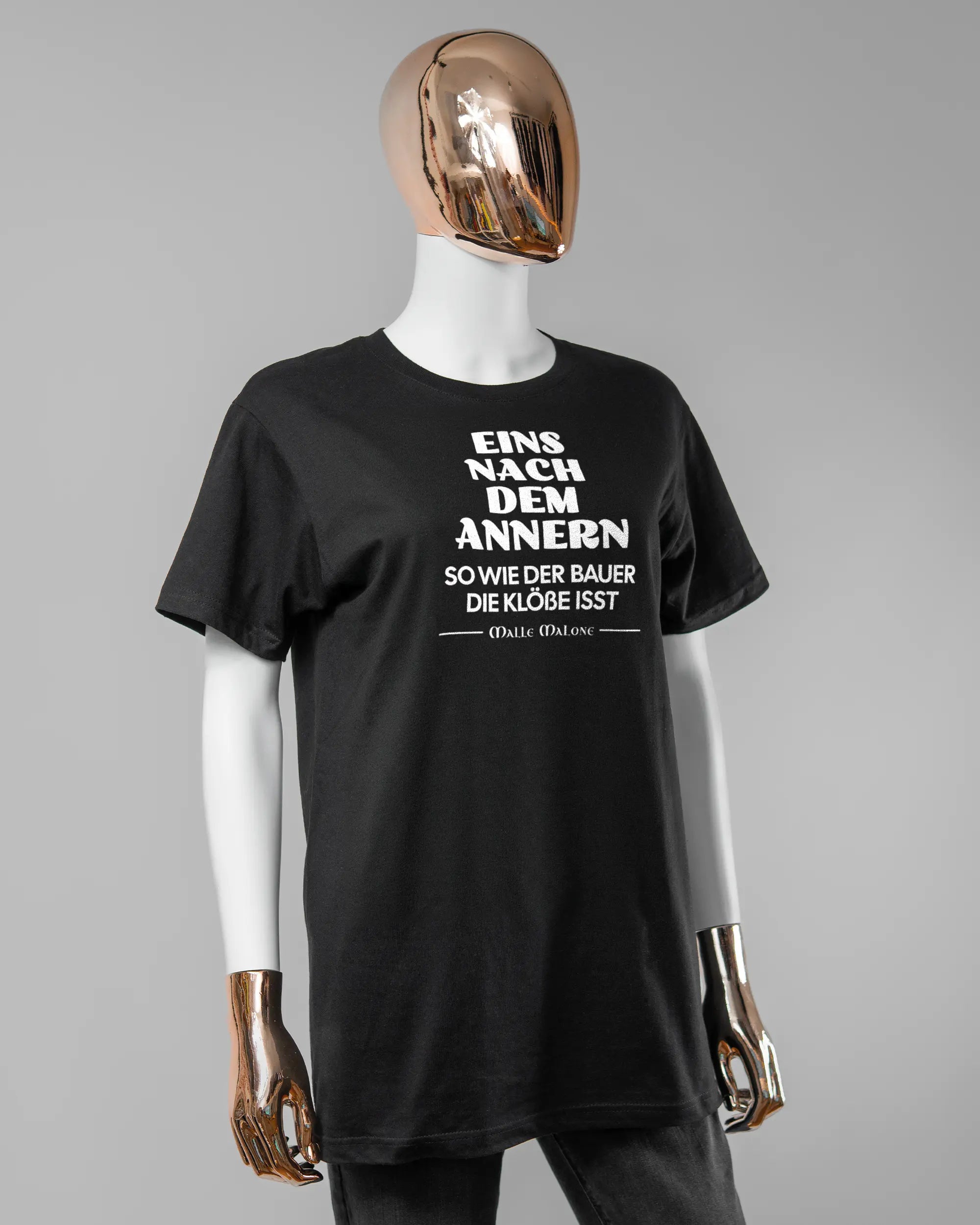 Vorderseite des Basic Unisex T-Shirt Soft von Maondo mit dem Design Eins nach dem Annern in der Farbe Black und in der Größe S getragen von einer femininen Puppe