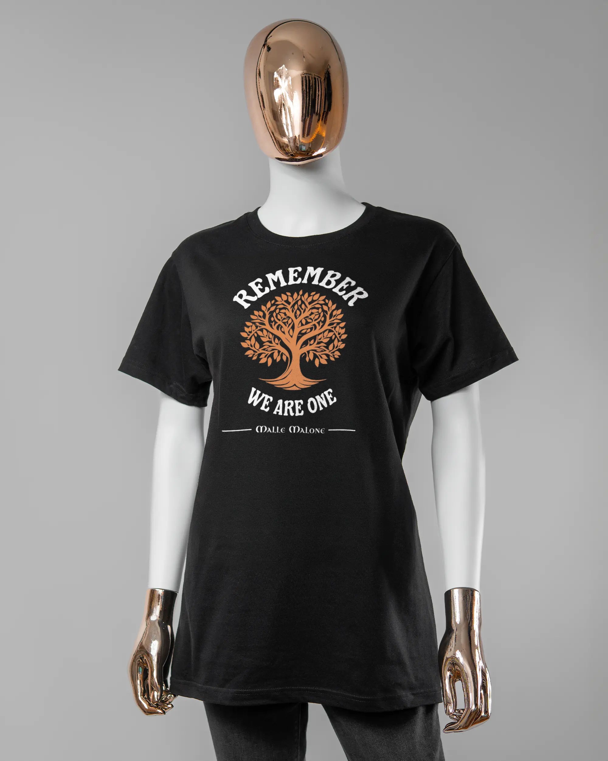Vorderseite des Basic Unisex T-Shirt Soft von Maondo mit dem Design We are one in der Farbe Black und in der Größe S getragen von einer femininen Puppe