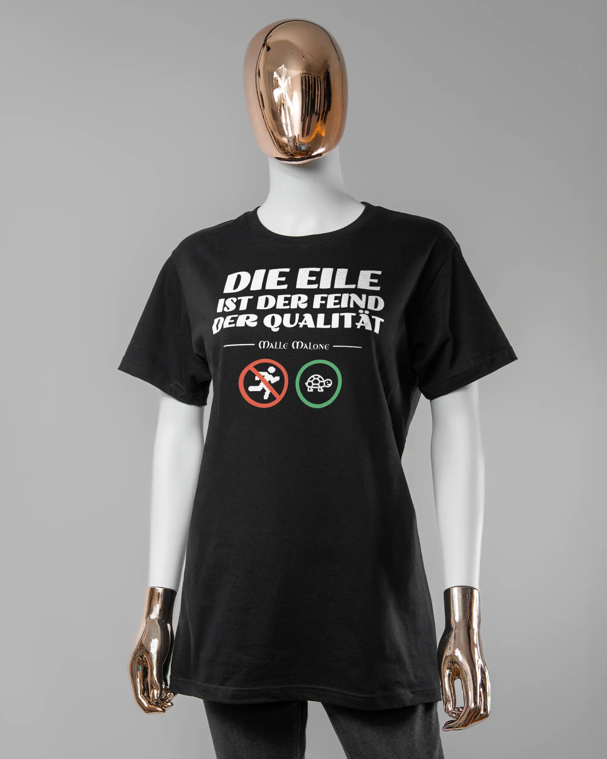 Vorderseite des Basic Unisex T-Shirt Soft von Maondo mit dem Design Keine Eile in der Farbe Black und in der Größe S getragen von einer femininen Puppe