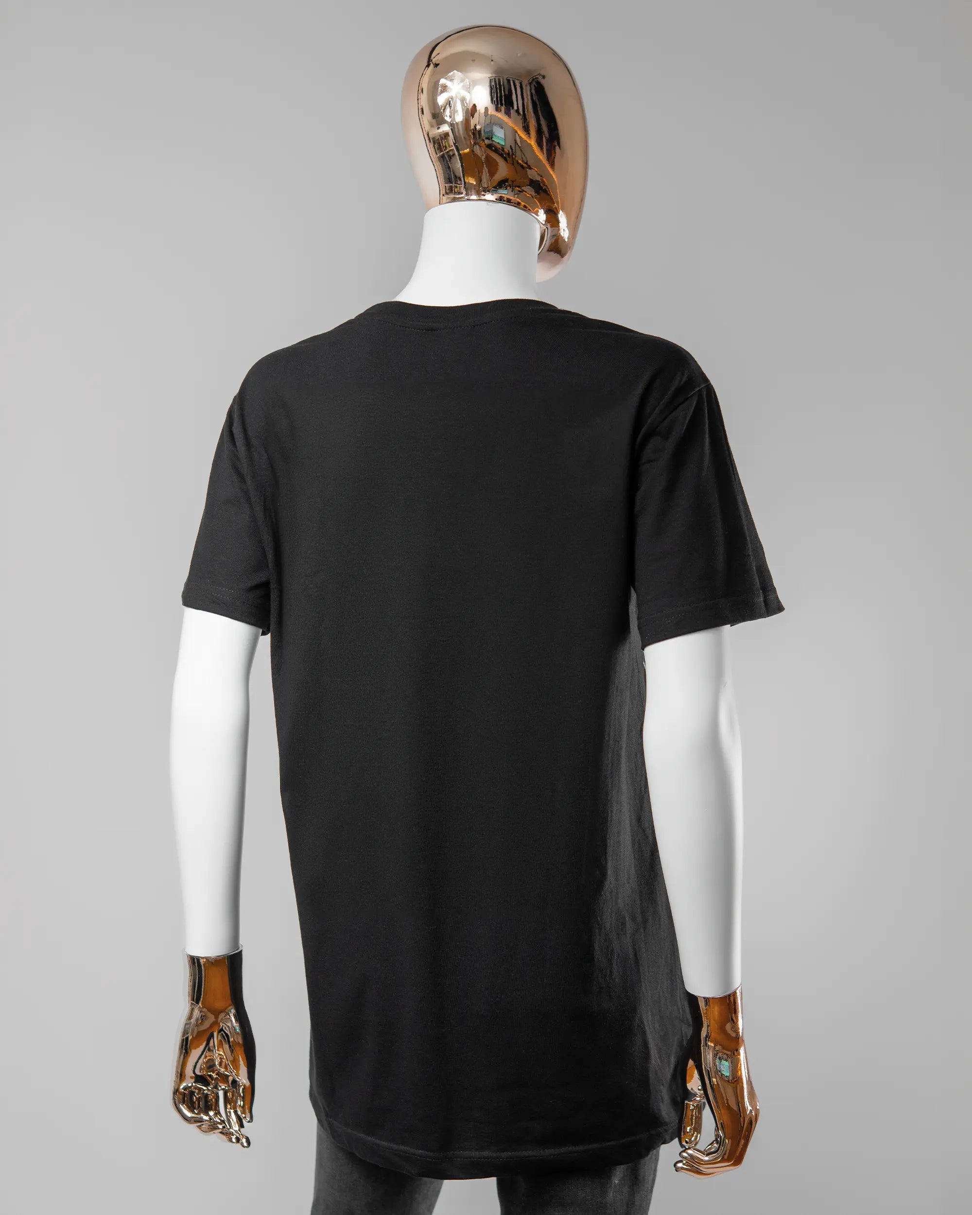 Rückseite des Basic Unisex T-Shirt Soft von Maondo ohne Motiv in der Farbe Black und in der Größe S getragen von einer femininen Puppe