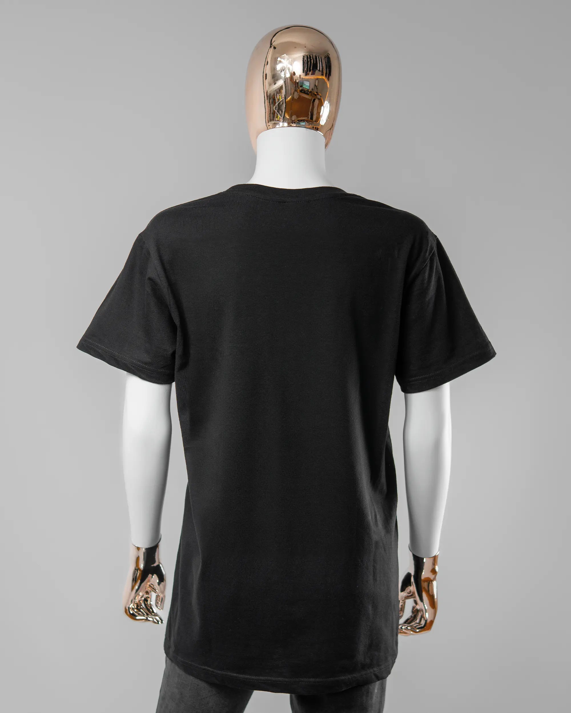 Rückseite des Basic Unisex T-Shirt Soft von Maondo ohne Motiv in der Farbe Black und in der Größe S getragen von einer femininen Puppe