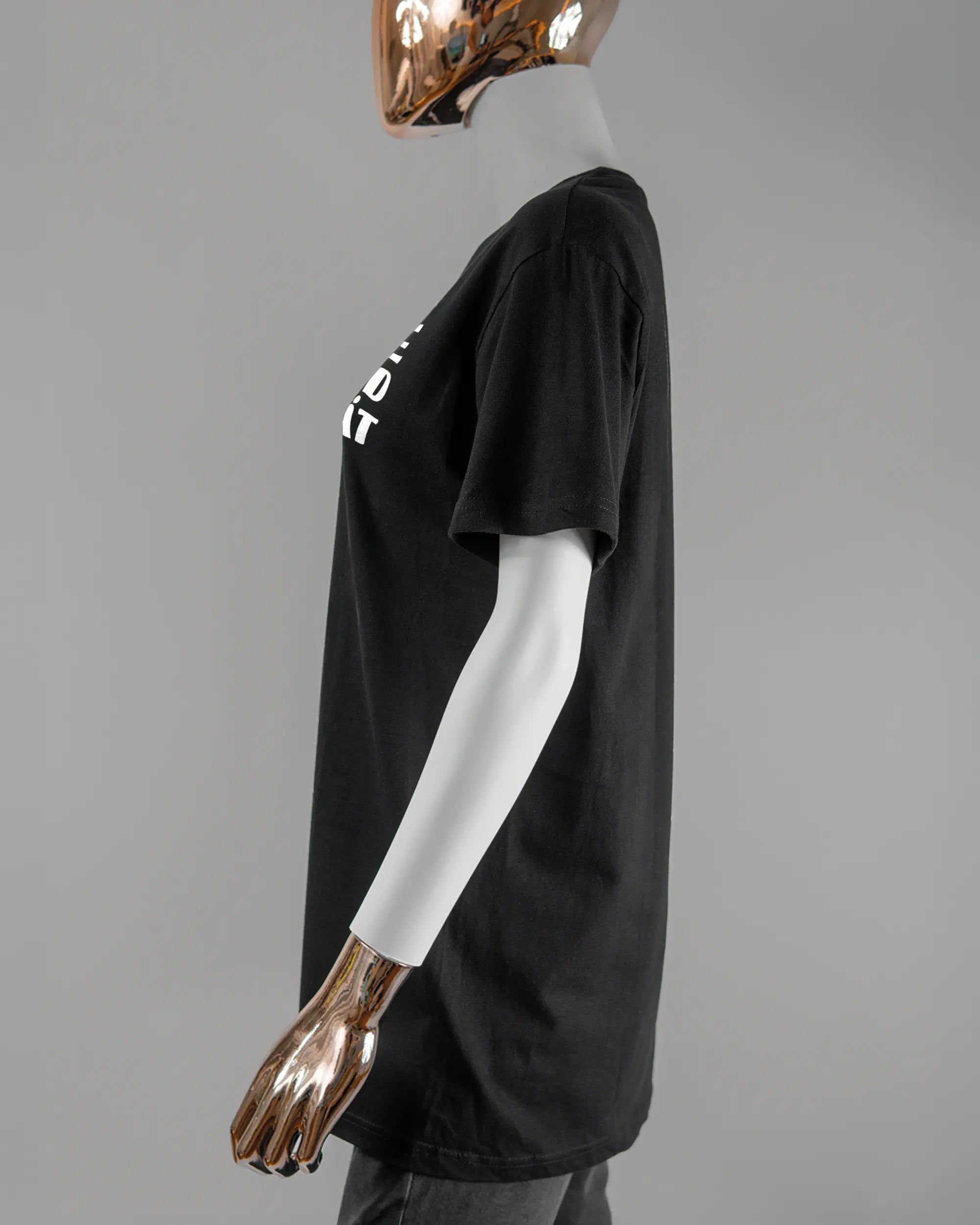 Seitenansicht des Basic Unisex T-Shirt Soft von Maondo mit dem Design Keine Eile vorne in der Farbe Black und in der Größe S getragen von einer femininen Puppe