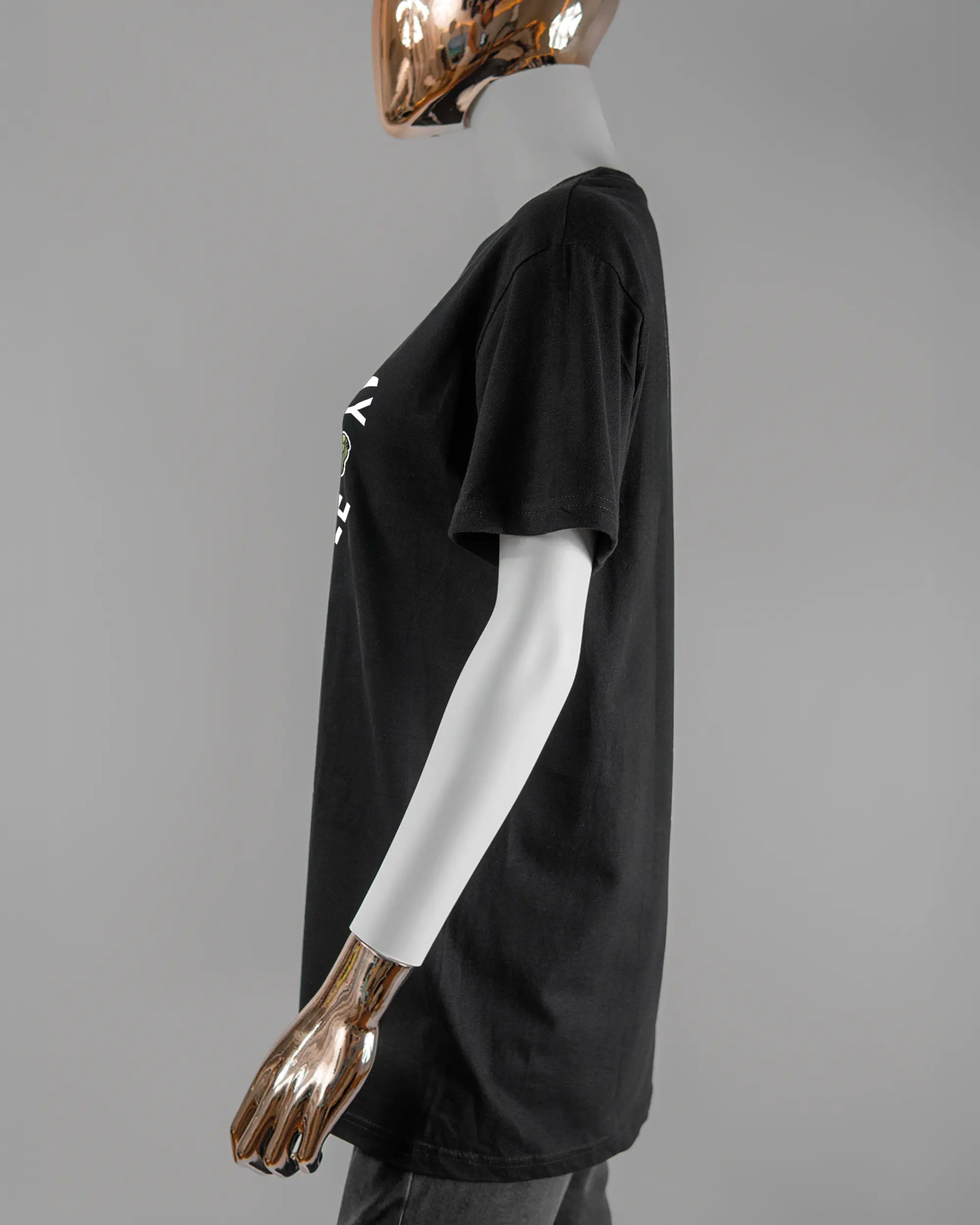 Seitenansicht des Basic Unisex T-Shirt Soft von Maondo mit dem Design Brocco-Lee vorne in der Farbe Black und in der Größe S getragen von einer femininen Puppe