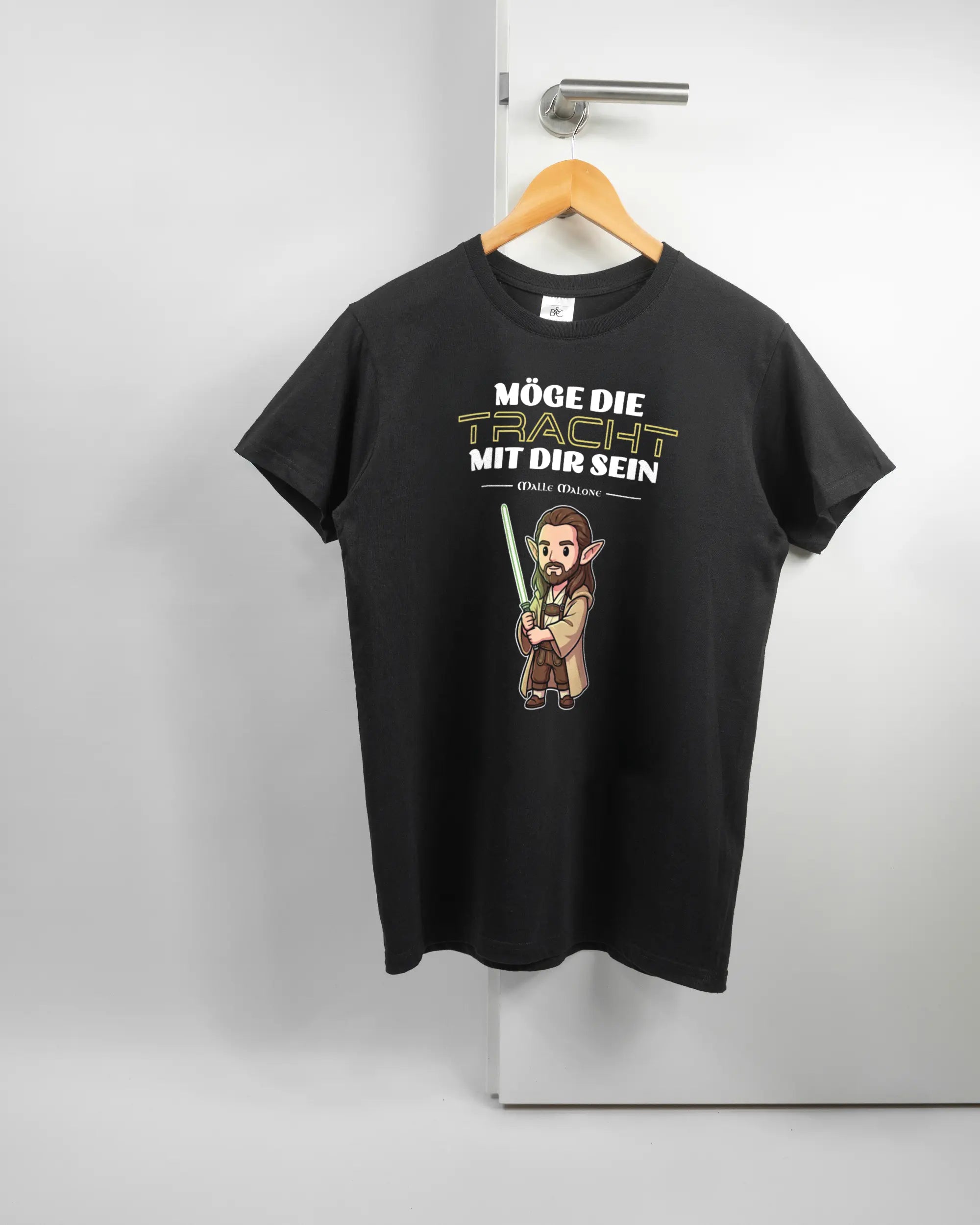 Vorderseite des Basic Unisex T-Shirt Soft von Maondo mit dem Design Tracht mit dir in der Farbe Black und in der Größe S auf einem Bügel an der Türklinke aufgehängt