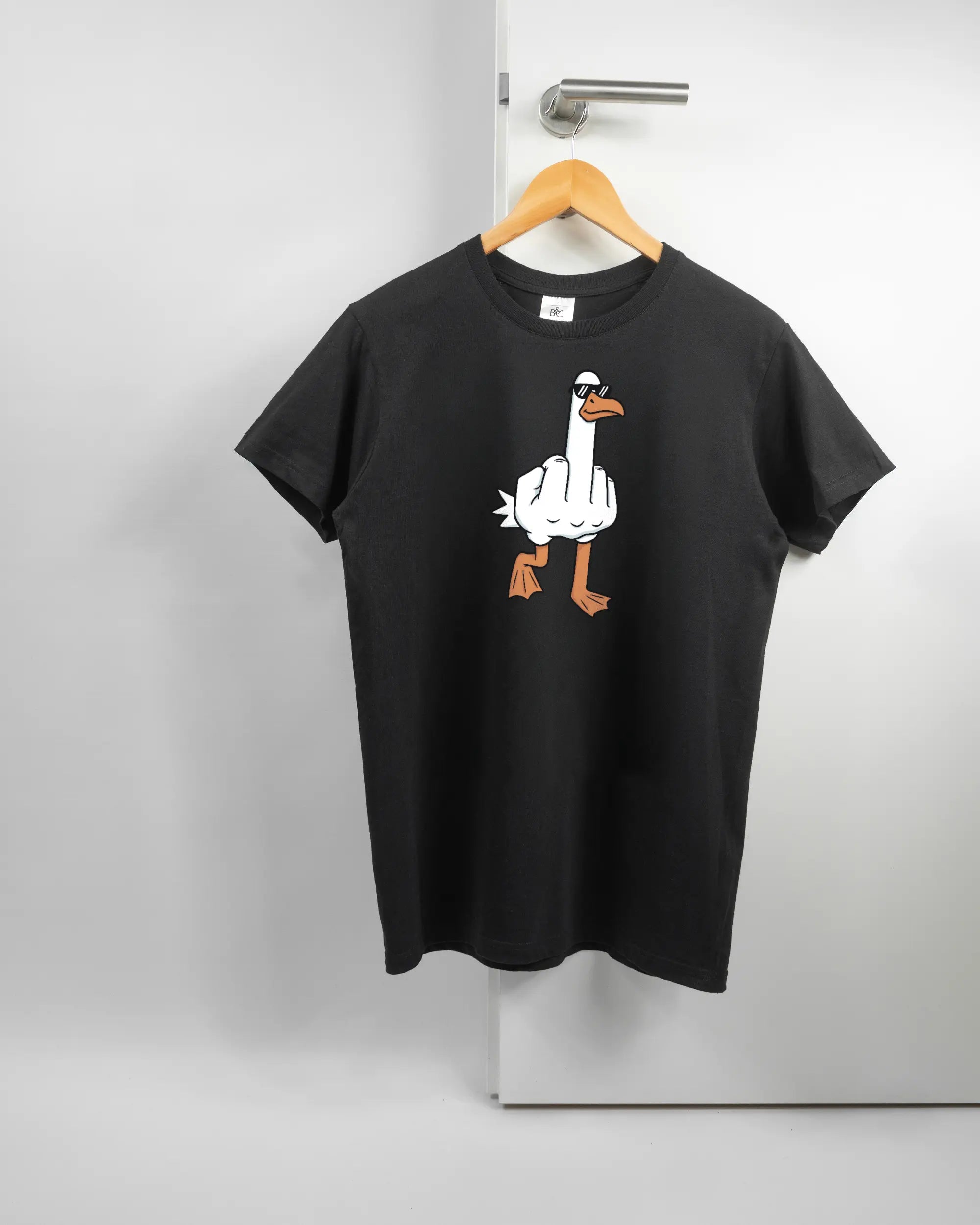 Vorderseite des Basic Unisex T-Shirt Soft von Maondo mit dem Design I give a duck in der Farbe Black und in der Größe S auf einem Bügel an der Türklinke aufgehängt