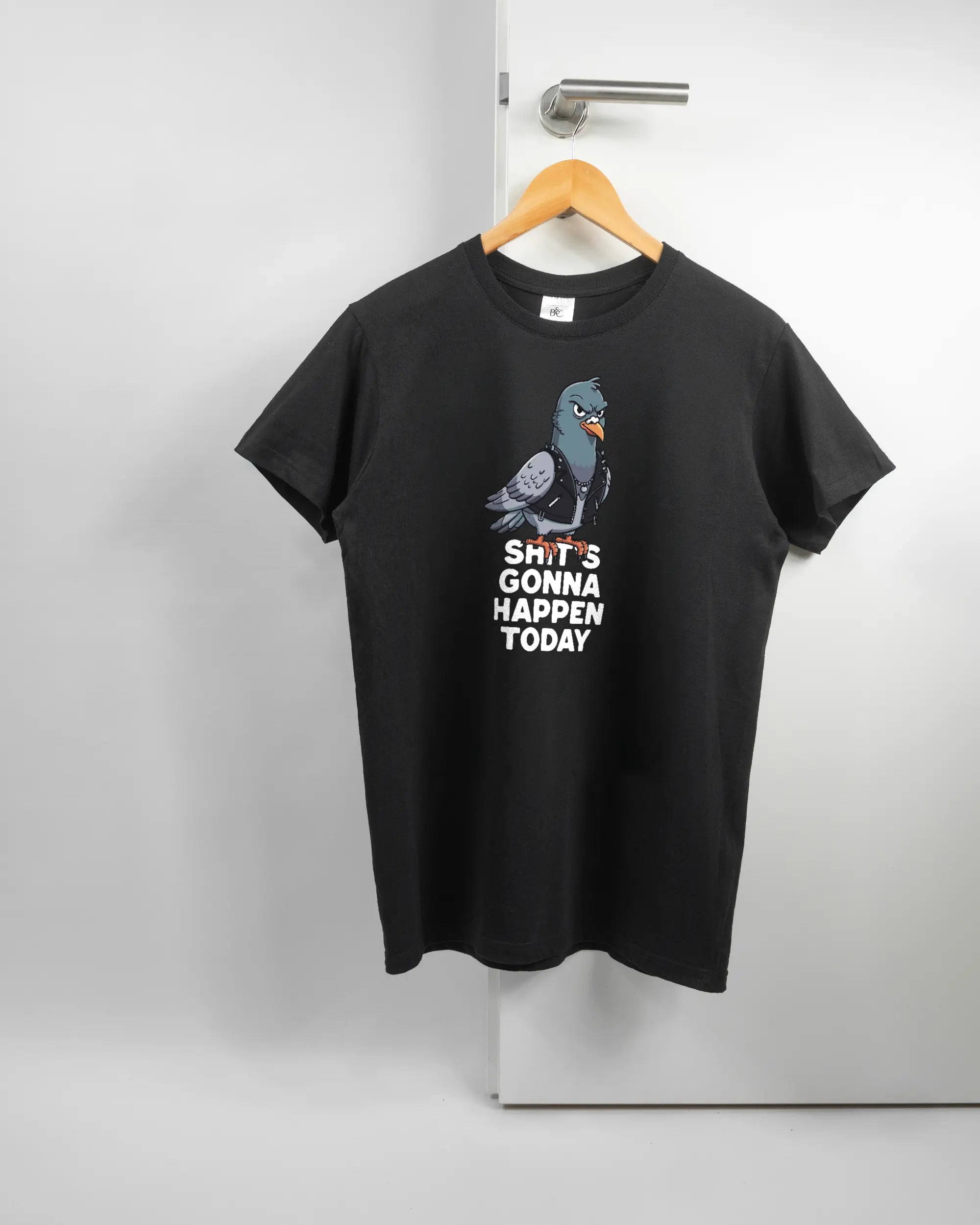 Vorderseite des Basic Unisex T-Shirt Soft von Maondo mit dem Design Pigeon Pun in der Farbe Black und in der Größe S auf einem Bügel an der Türklinke aufgehängt