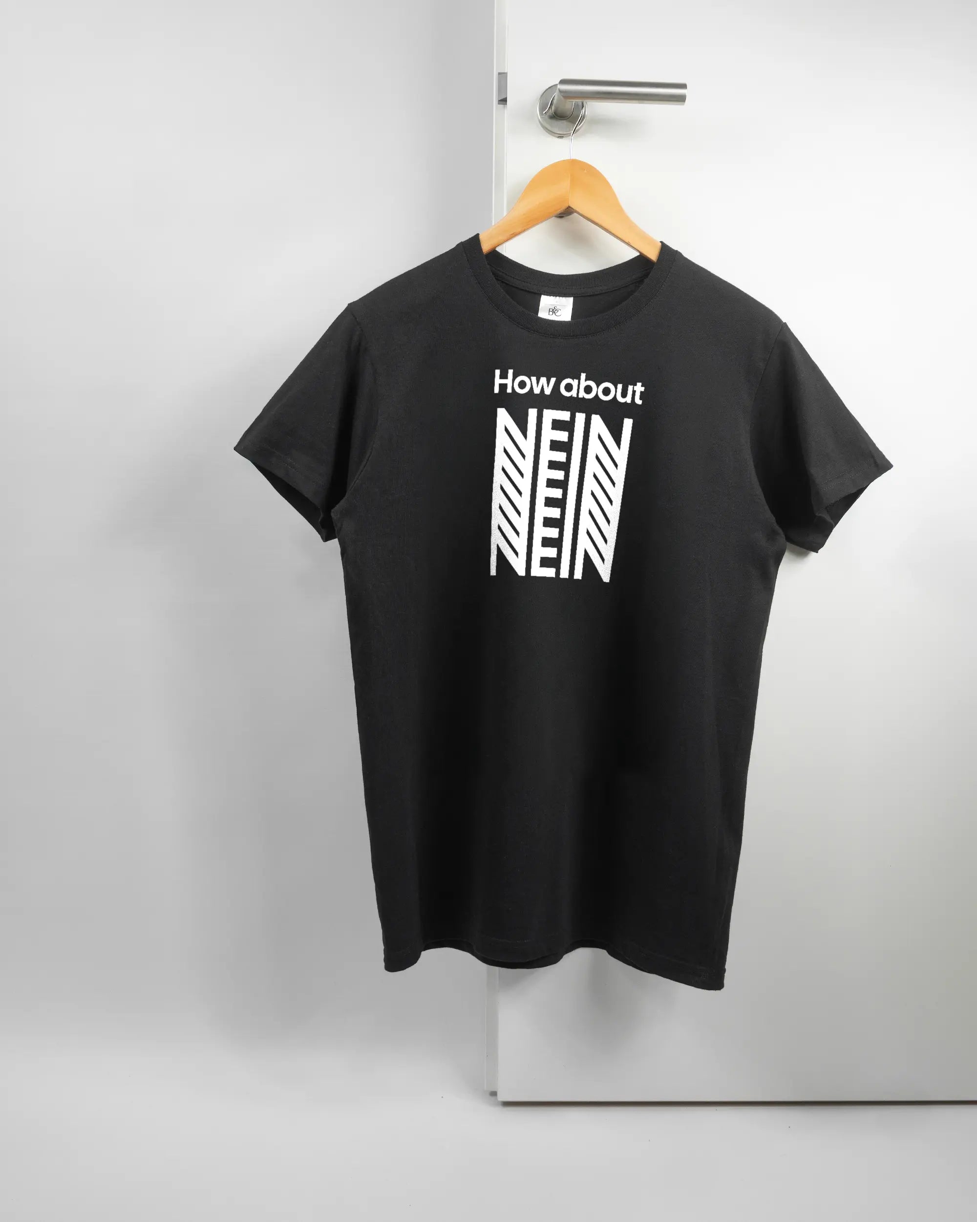 Vorderseite des Basic Unisex T-Shirt Soft von Maondo mit dem Design How about nein in der Farbe Black und in der Größe S auf einem Bügel an der Türklinke aufgehängt