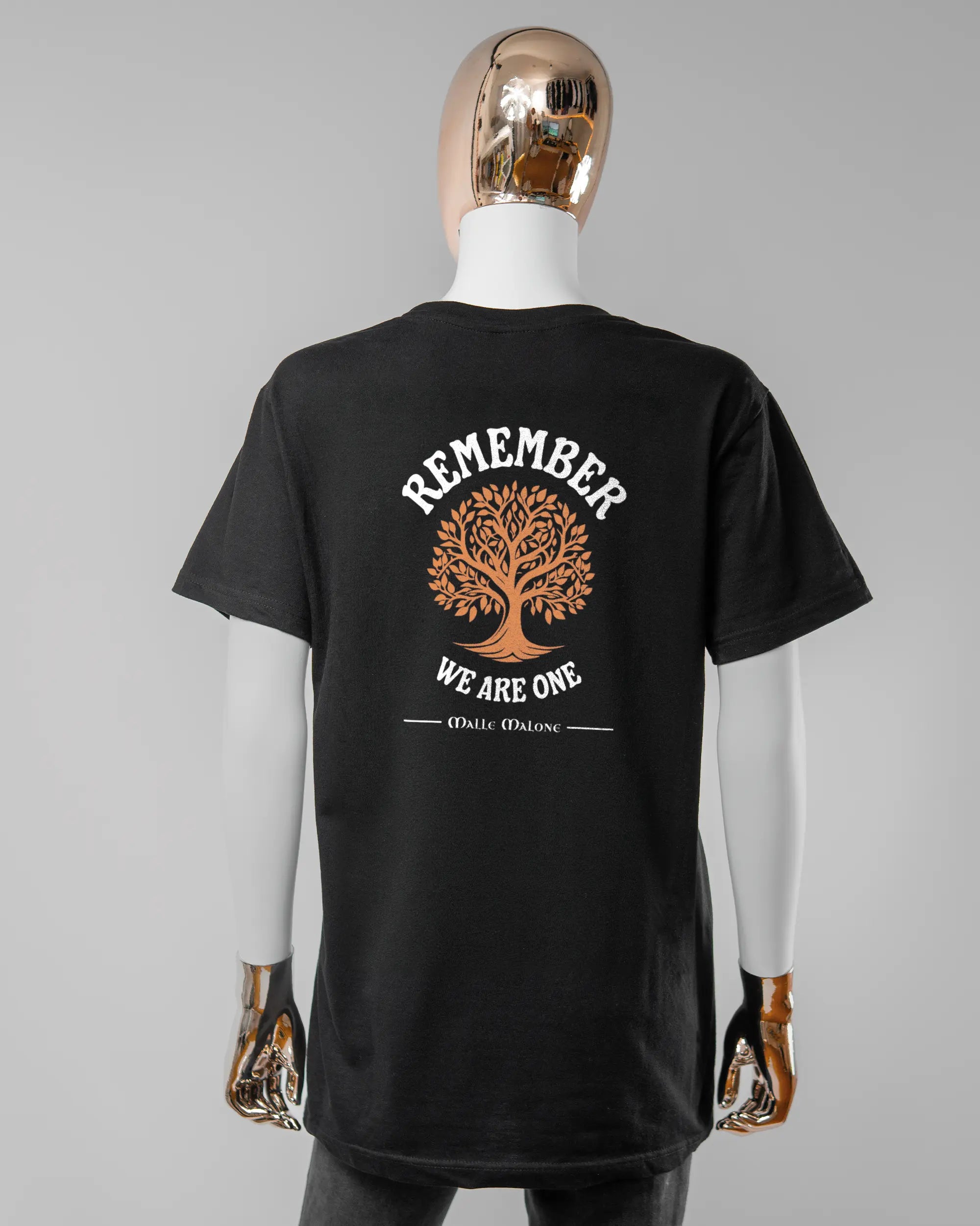 Rückseite des Basic Unisex T-Shirt Soft von Maondo mit dem Design We are one in der Farbe Black und in der Größe S getragen von einer femininen Puppe