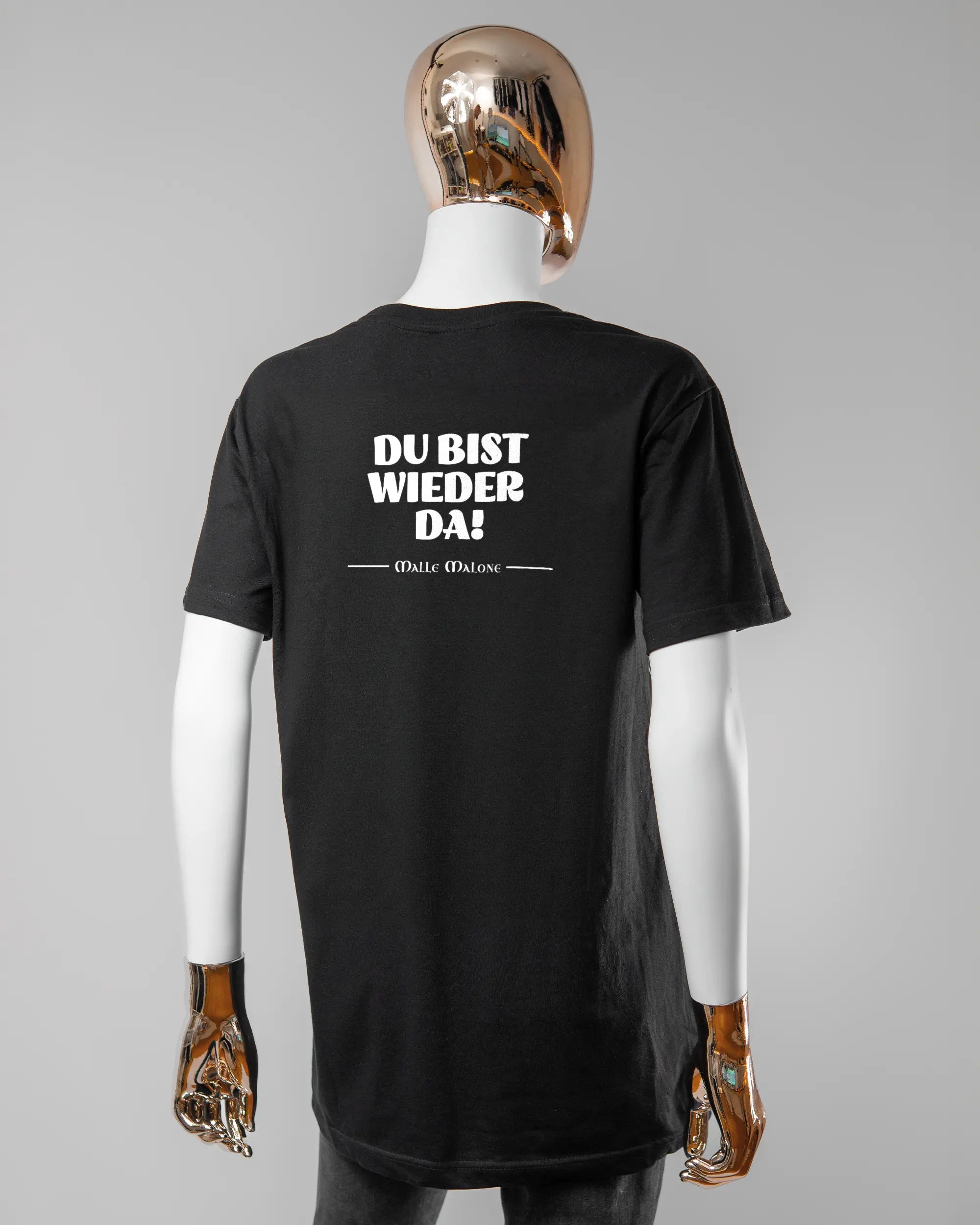 Rückseite des Basic Unisex T-Shirt Soft von Maondo mit dem Design Wieder da in der Farbe Black und in der Größe S getragen von einer femininen Puppe