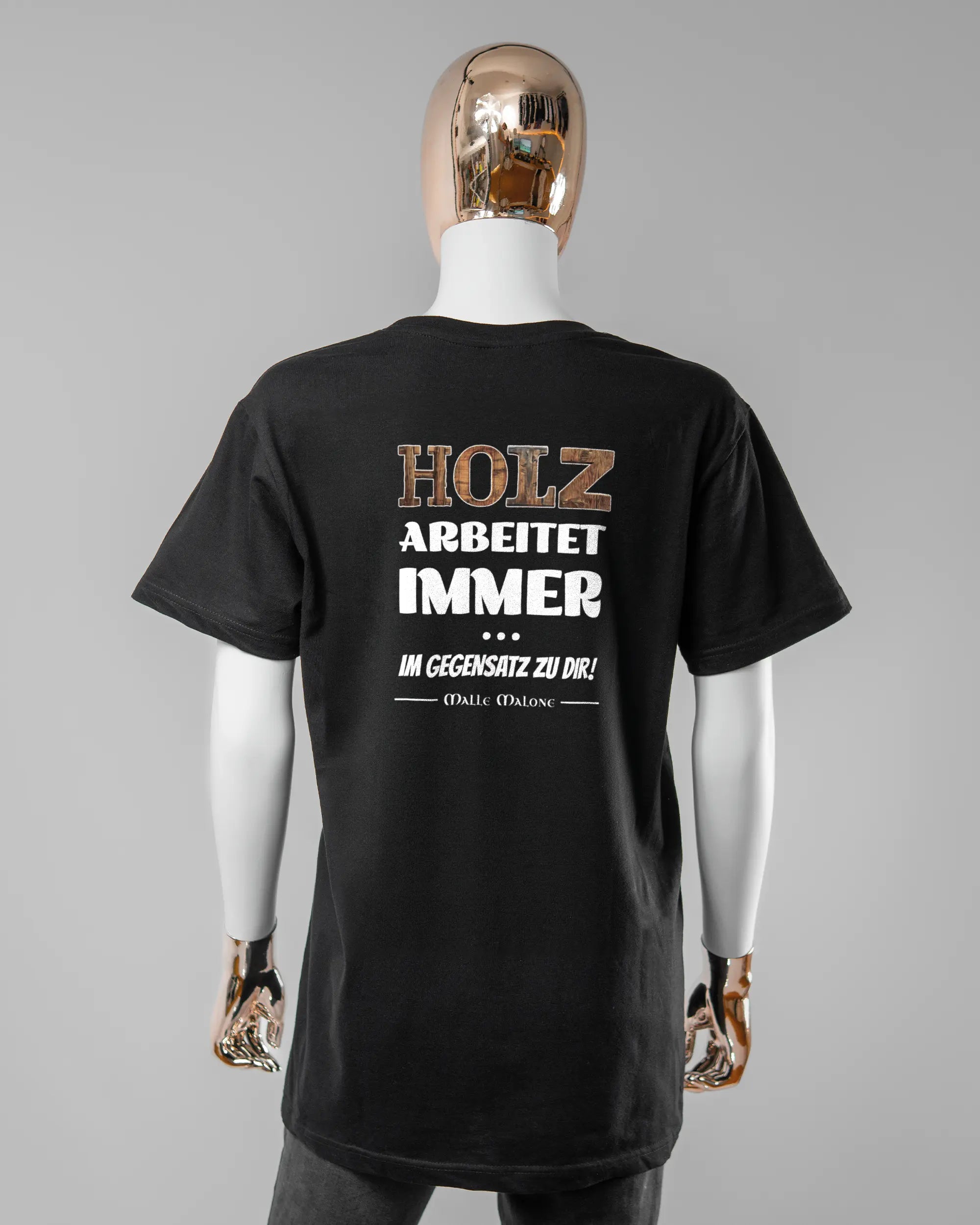 Rückseite des Basic Unisex T-Shirt Soft von Maondo mit dem Design Holzarbeit in der Farbe Black und in der Größe S getragen von einer femininen Puppe