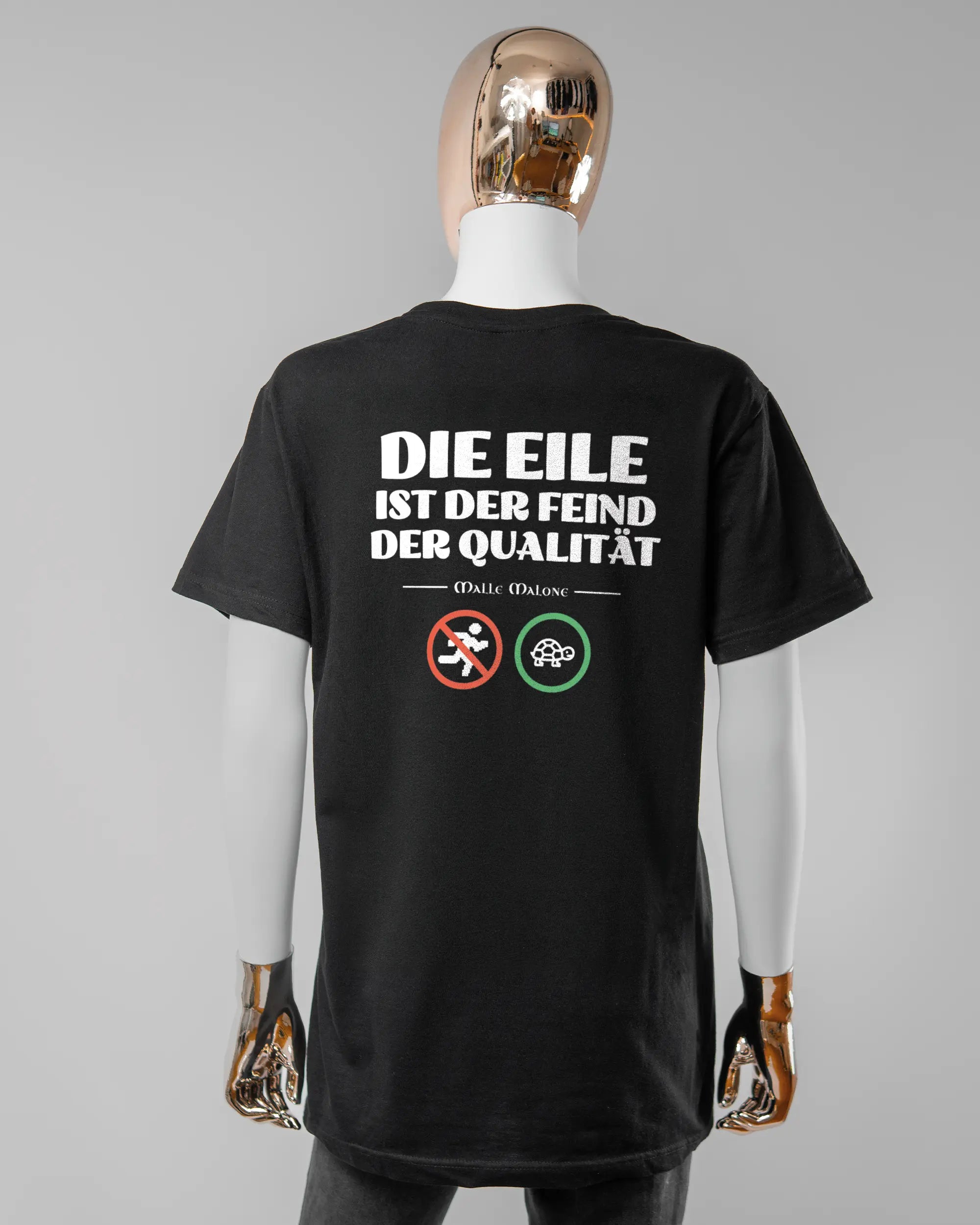 Rückseite des Basic Unisex T-Shirt Soft von Maondo mit dem Design Keine Eile in der Farbe Black und in der Größe S getragen von einer femininen Puppe
