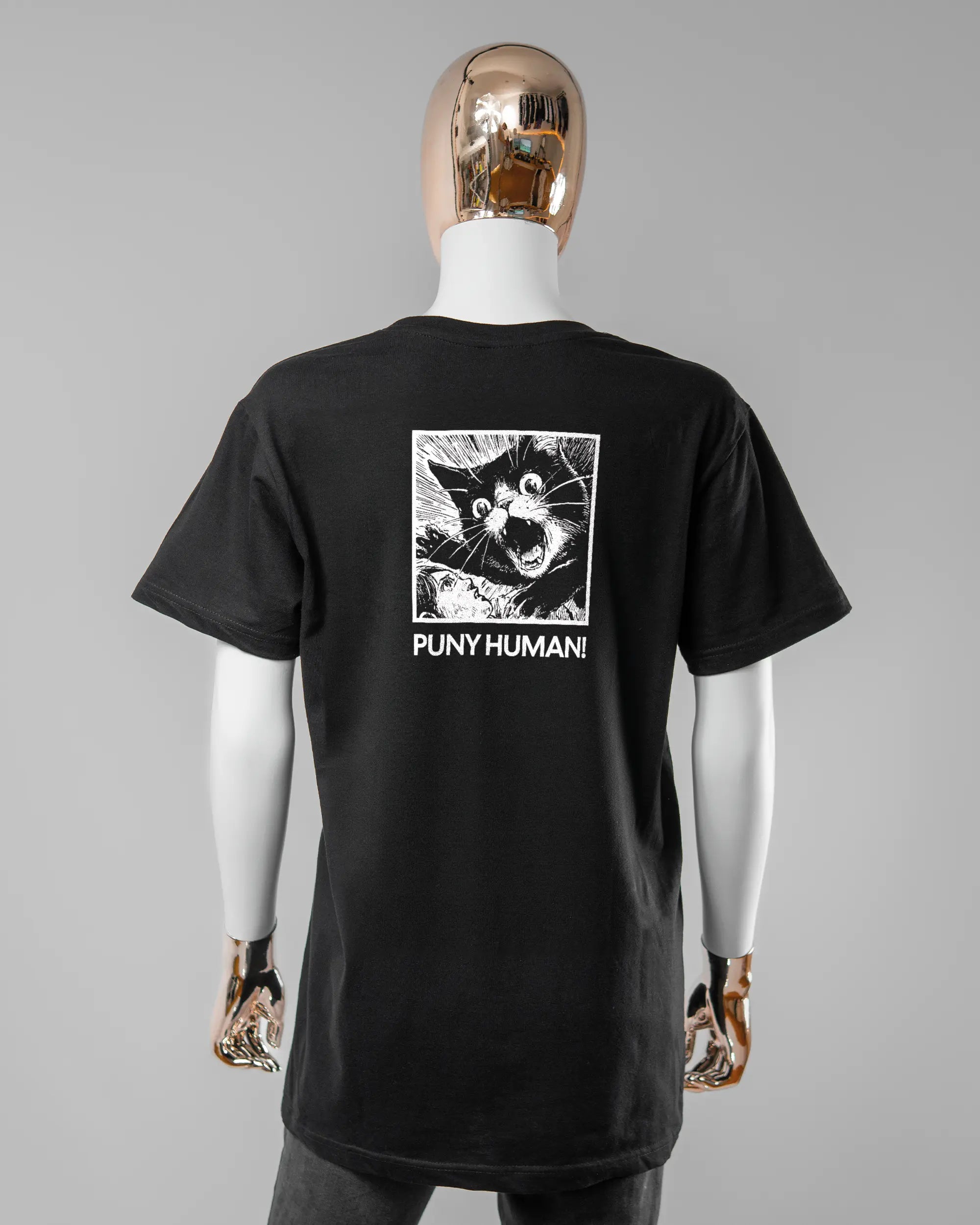 Rückseite des Basic Unisex T-Shirt Soft von Maondo mit dem Design Puny Human in der Farbe Black und in der Größe S getragen von einer femininen Puppe