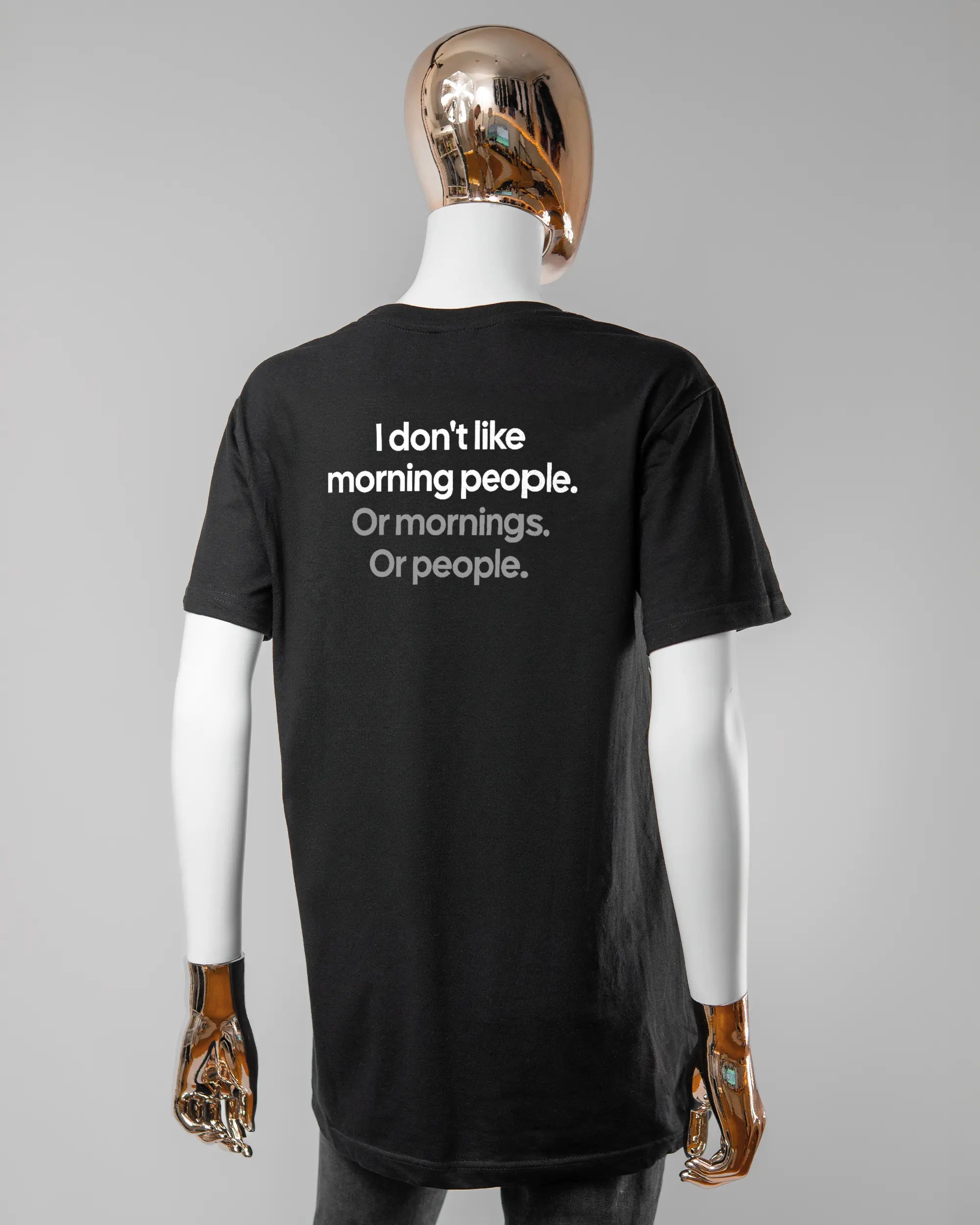 Rückseite des Basic Unisex T-Shirt Soft von Maondo mit dem Design Morning Person in der Farbe Black und in der Größe S getragen von einer femininen Puppe