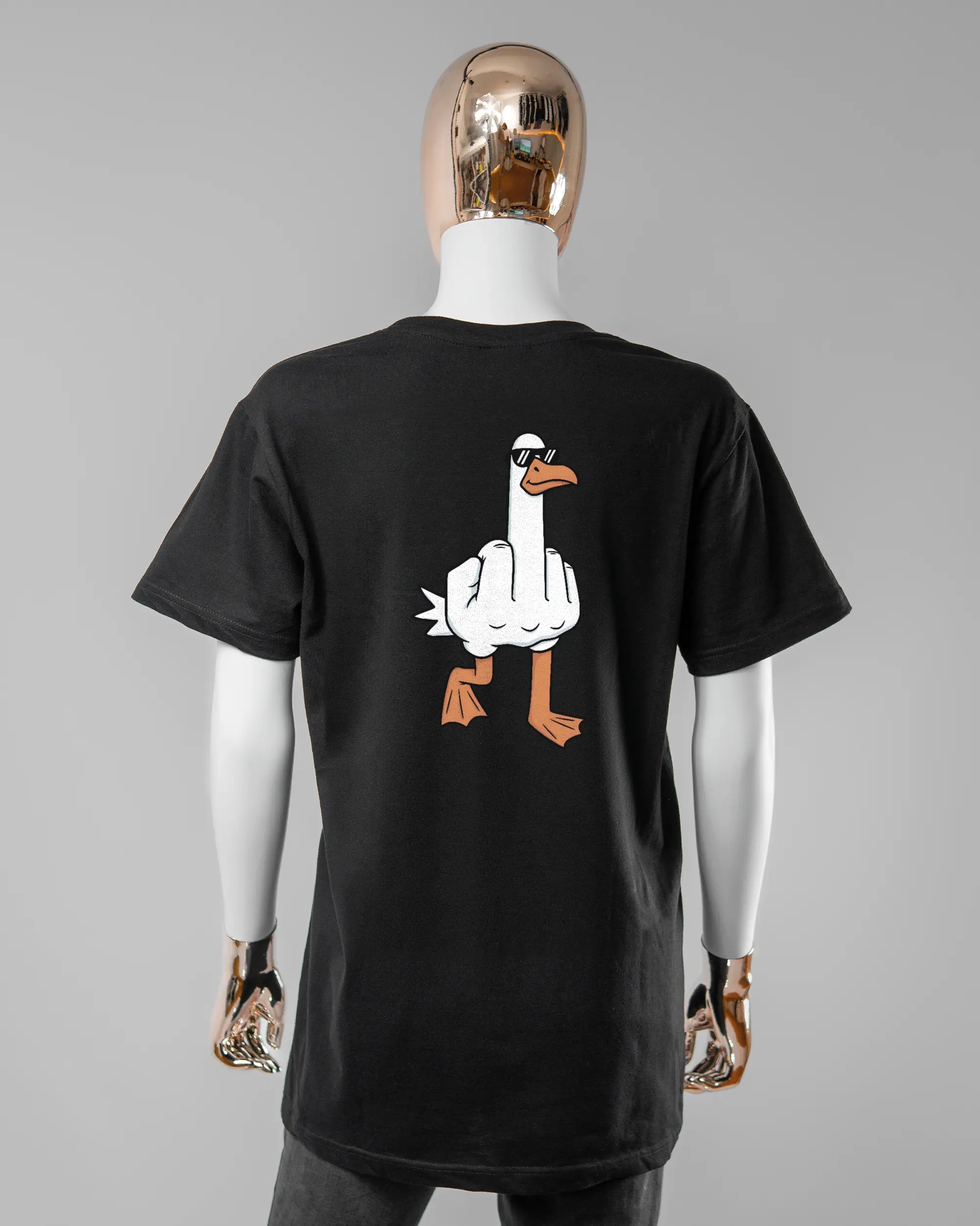 Rückseite des Basic Unisex T-Shirt Soft von Maondo mit dem Design I give a duck in der Farbe Black und in der Größe S getragen von einer femininen Puppe