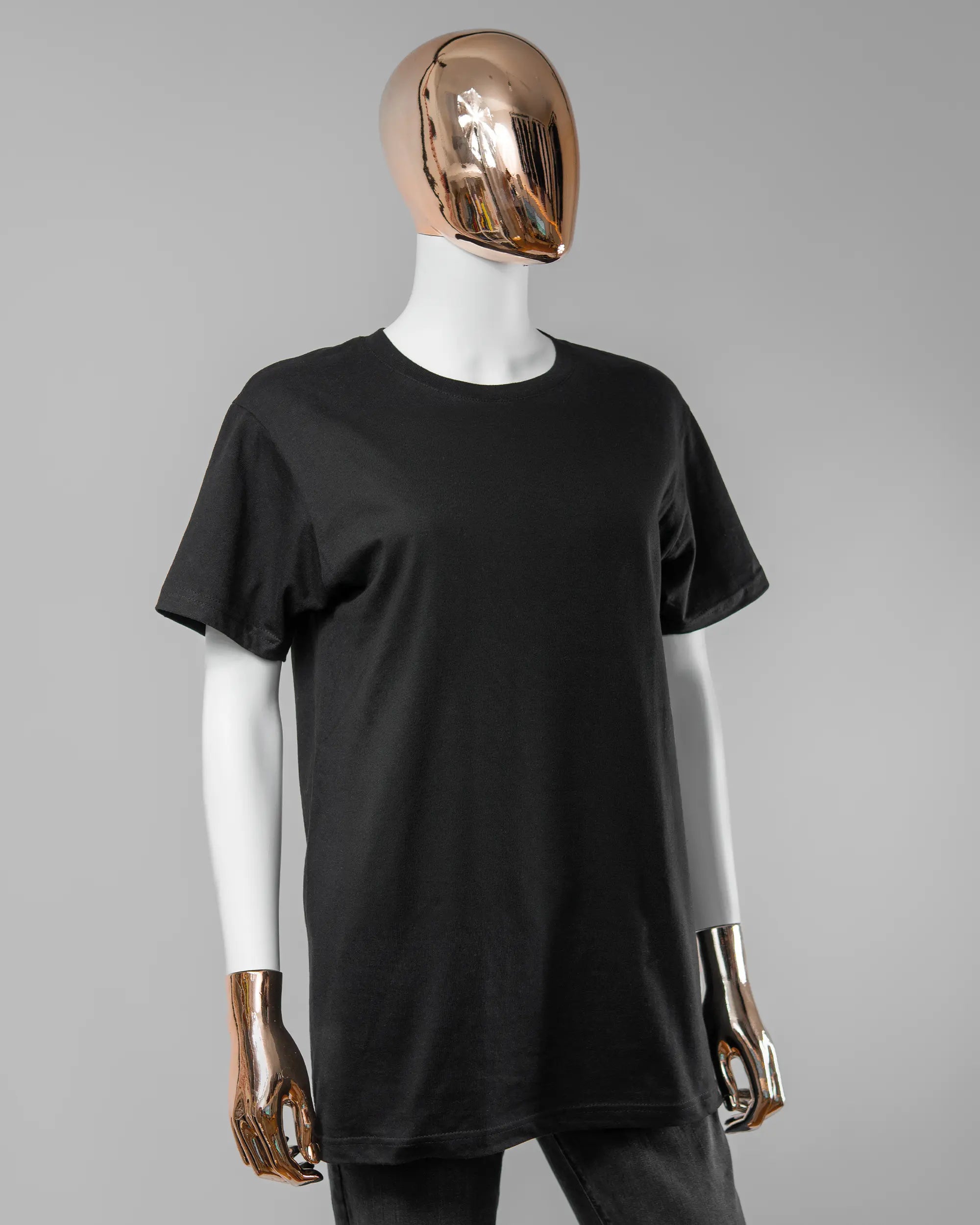 Vorderseite des Basic Unisex T-Shirt Soft von Maondo ohne Motiv in der Farbe Black und in der Größe S getragen von einer femininen Puppe