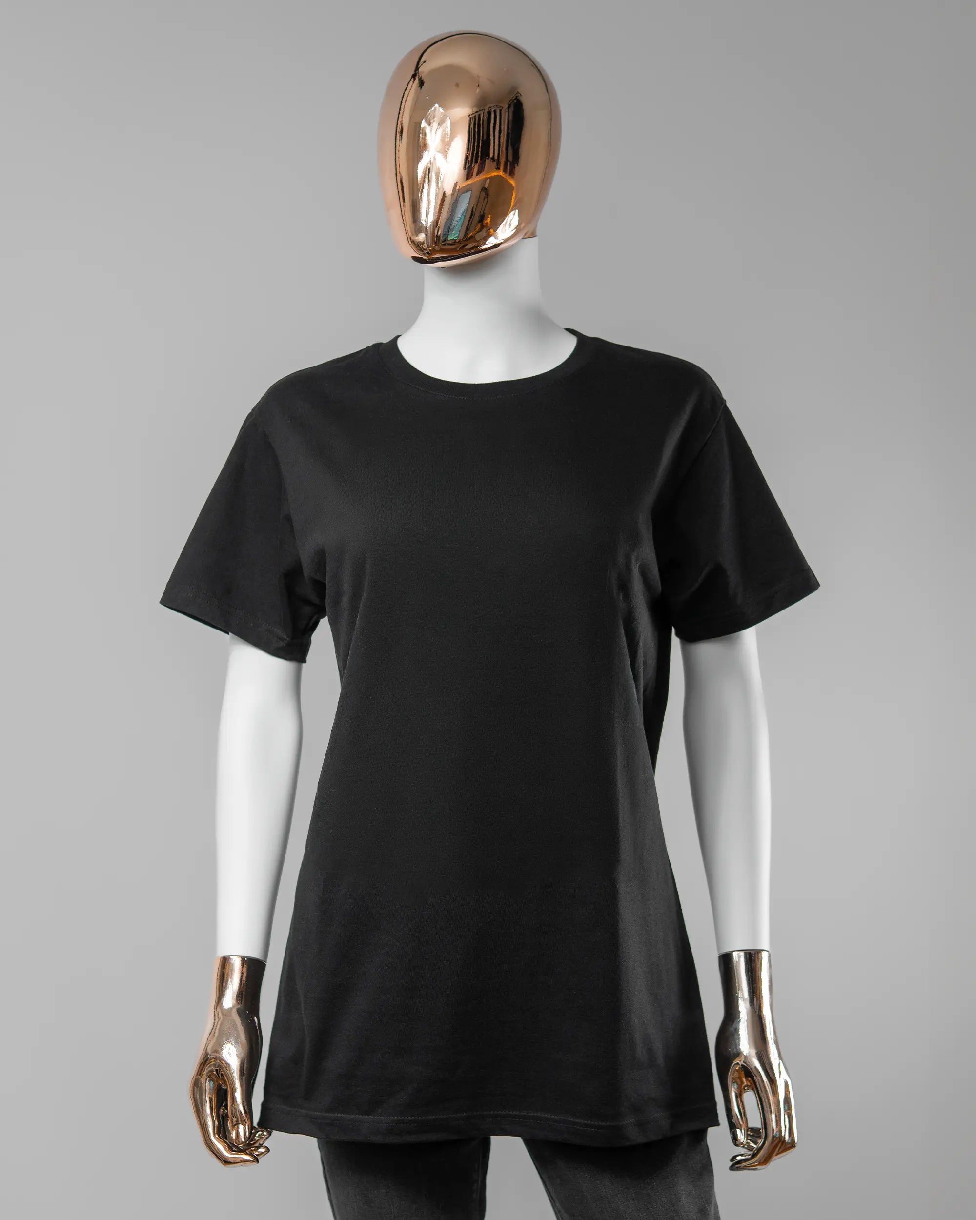 Vorderseite des Basic Unisex T-Shirt Soft von Maondo ohne Motiv in der Farbe Black und in der Größe S getragen von einer femininen Puppe