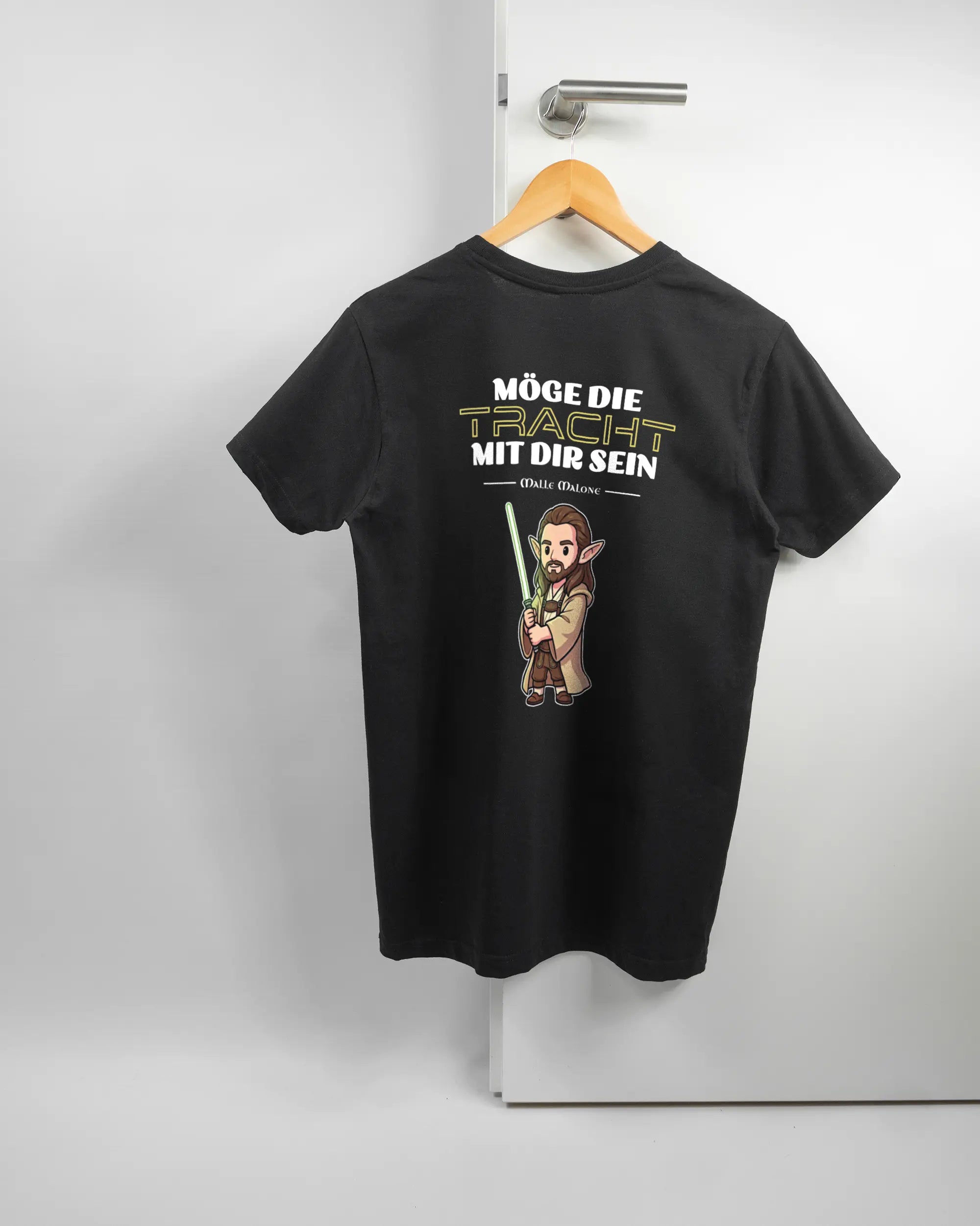 Rückseite des Basic Unisex T-Shirt Soft von Maondo mit dem Design Tracht mit dir in der Farbe Black und in der Größe S auf einem Bügel an der Türklinke aufgehängt