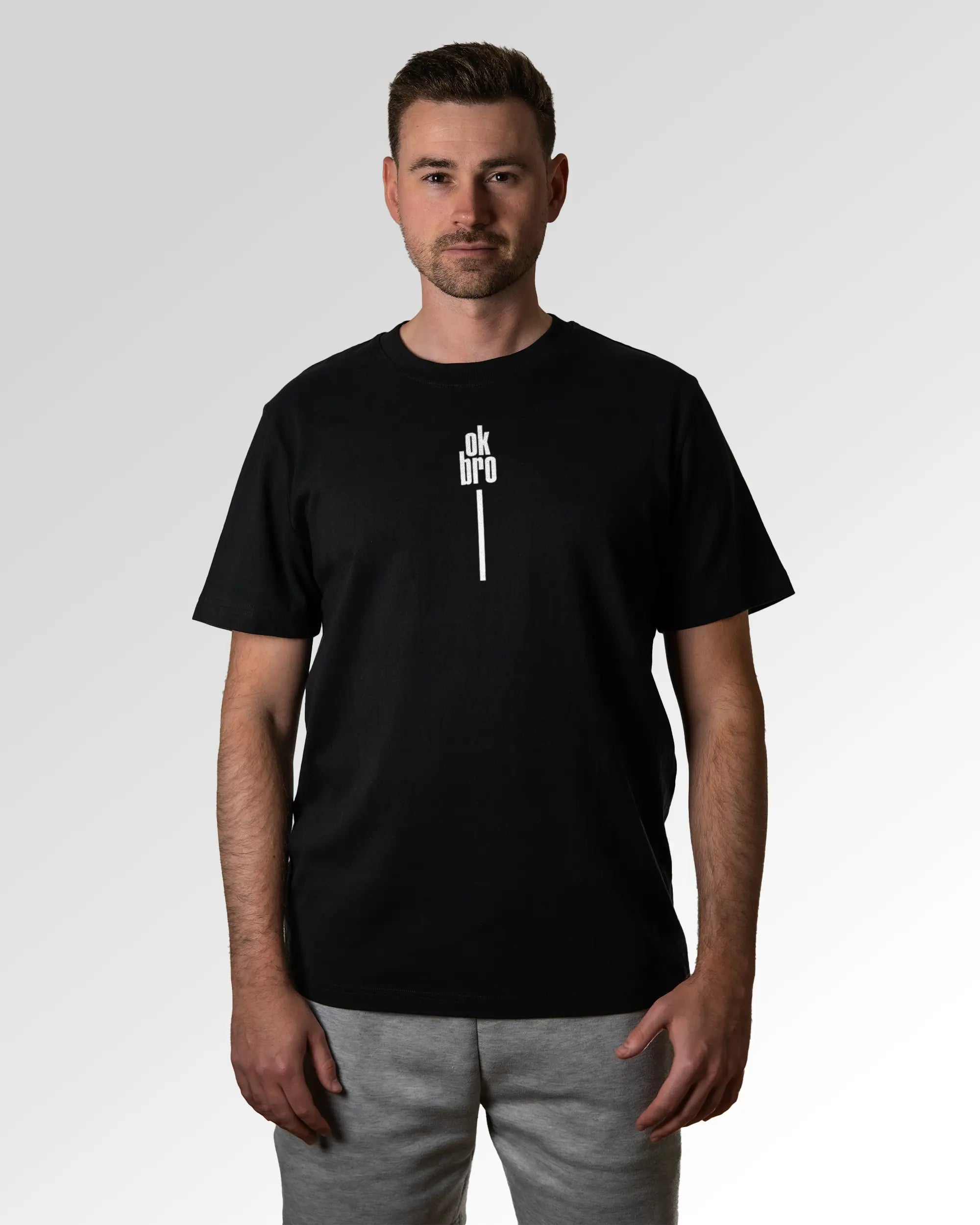 Primärer Modelshot der Druckseite des Organic Unisex T-Shirts von Maondo im Heavy Fit mit dem Design Okay Bro in der Farbe Black