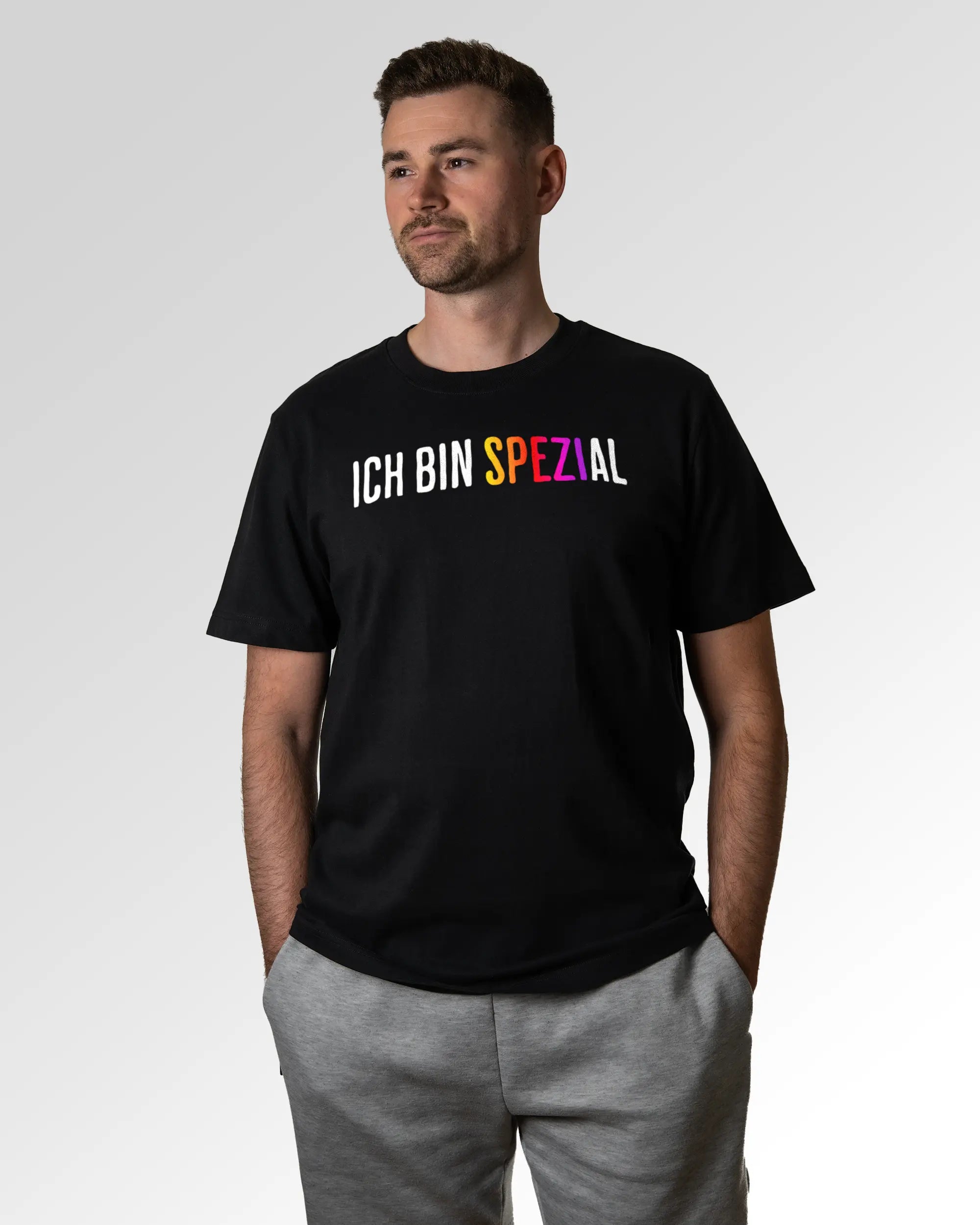 Primärer Modelshot der Druckseite des Organic Unisex T-Shirts von Maondo im Heavy Fit mit dem Design Ich bin Spezial in der Farbe Black