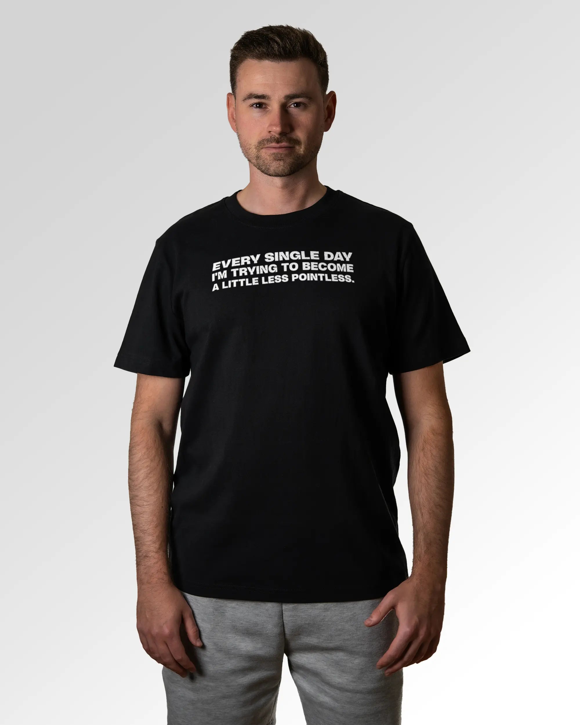 Primärer Modelshot der Druckseite des Organic Unisex T-Shirts von Maondo im Heavy Fit mit dem Design Less Pointless in der Farbe Black