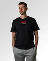 Männlicher Modelshot der primären Druckseite des Organic Unisex T-Shirts von Maondo im Relaxed Fit mit dem Design Authentic Shit in der Farbe Black