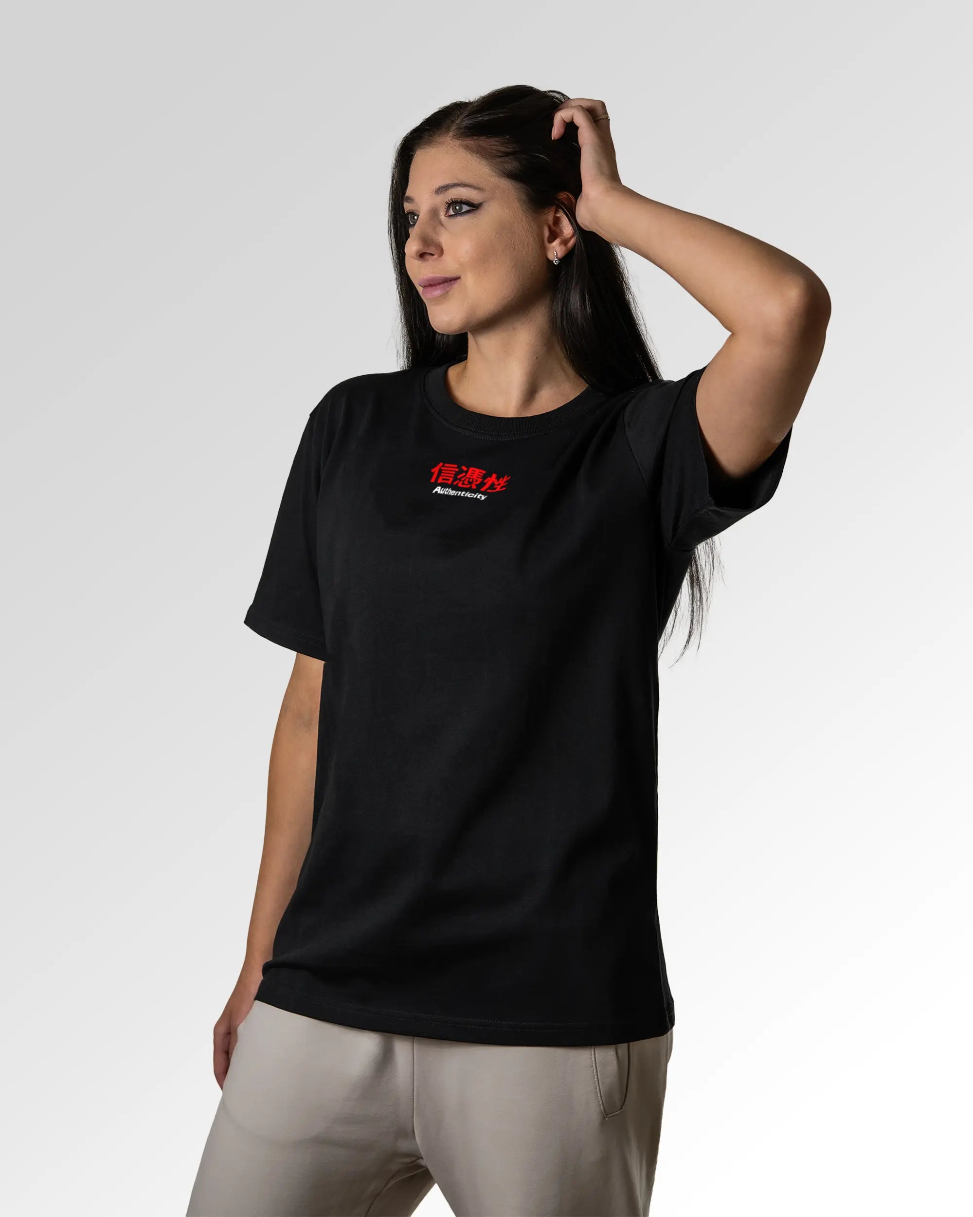 Weiblicher Modelshot der primären Druckseite des Organic Unisex T-Shirts von Maondo im Relaxed Fit mit dem Design Authentic Shit in der Farbe Black