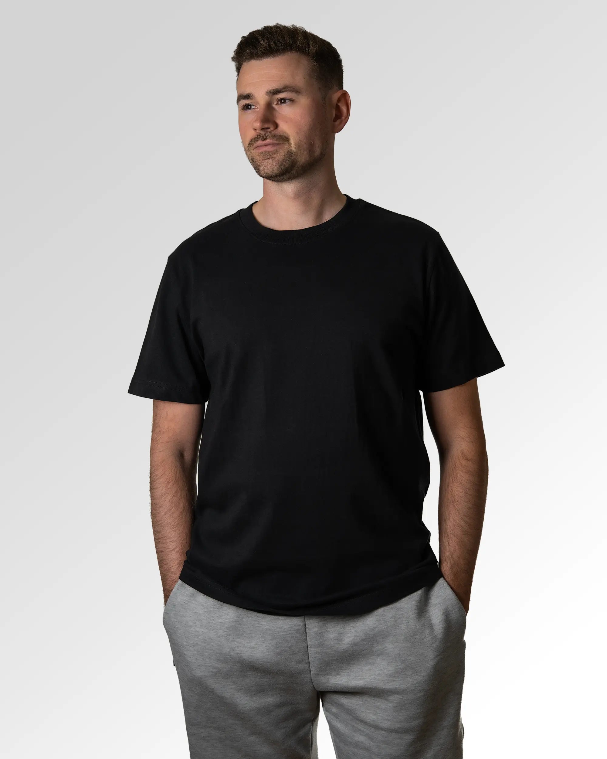 Primärer Modelshot der unbedruckten Seite des Organic Unisex T-Shirts von Maondo im Heavy Fit mit dem Design Schein Breit in der Farbe Black