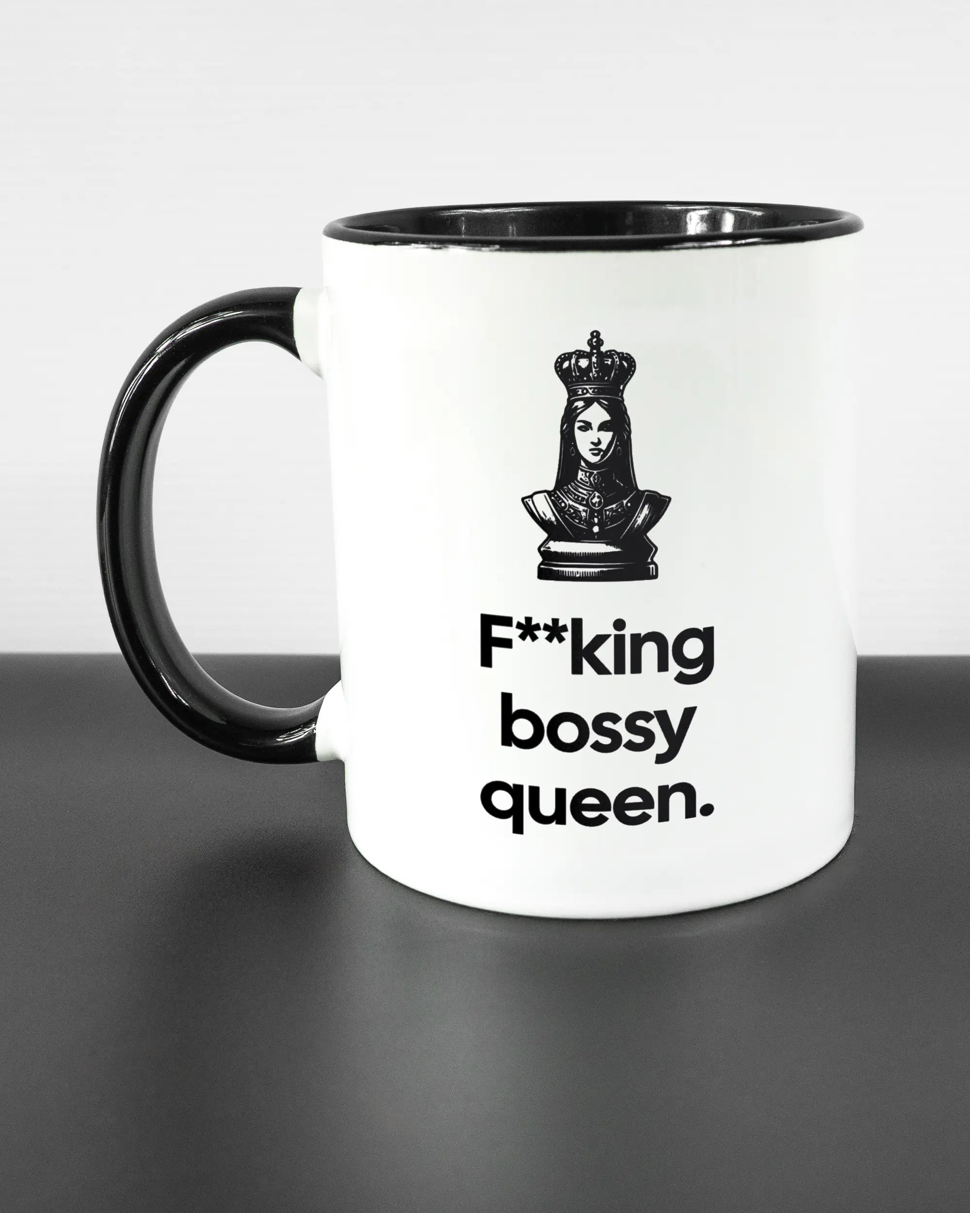 Titelbild, das die linke Seite der beidseitig bedruckten Keramiktasse von Maondo mit dem Design Bossy Queen in der Farbe Duotone auf einem Holztisch zeigt