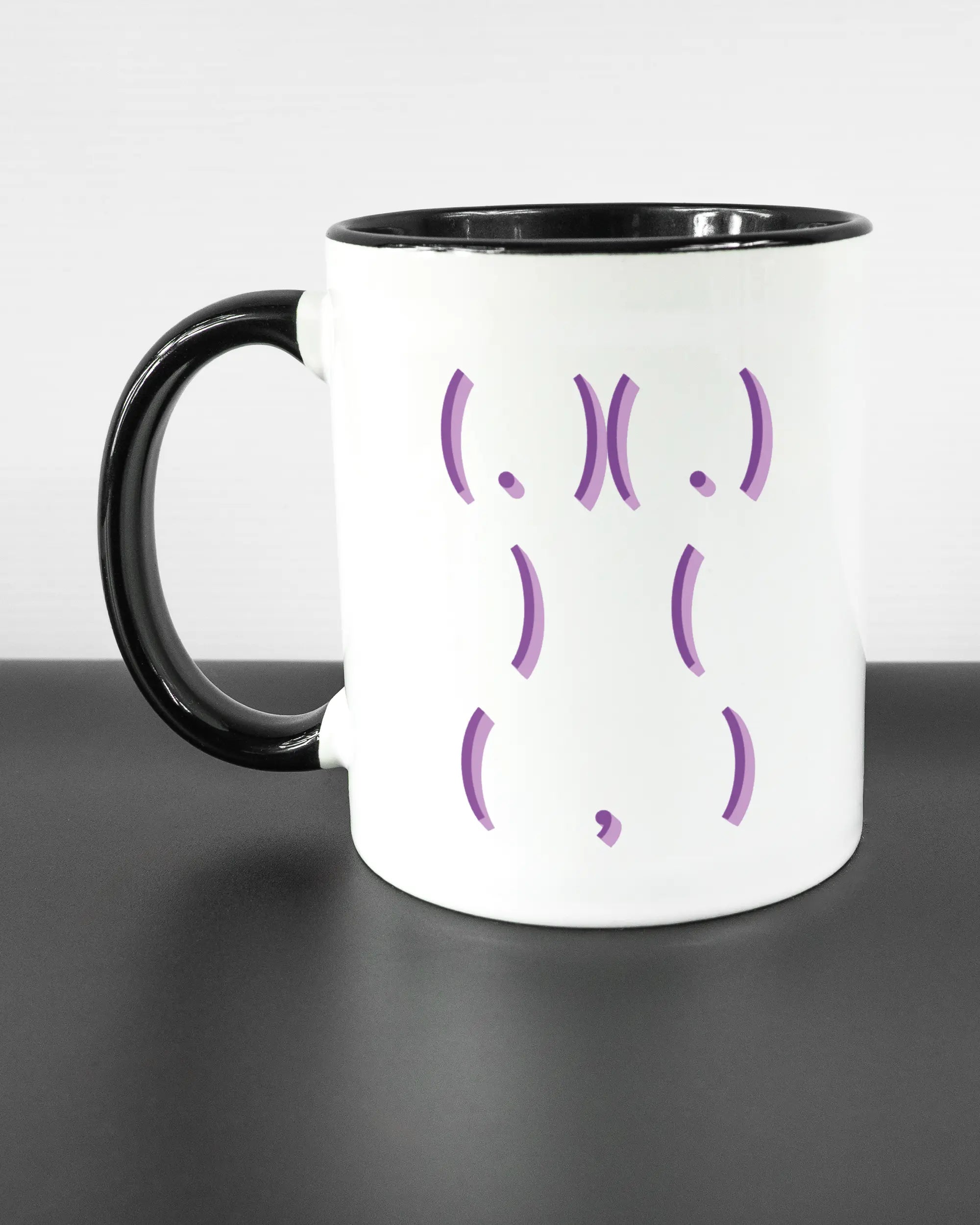 Titelbild, das die linke Seite der beidseitig bedruckten Keramiktasse von Maondo mit dem Design Body Language in der Farbe Duotone auf einem Holztisch zeigt