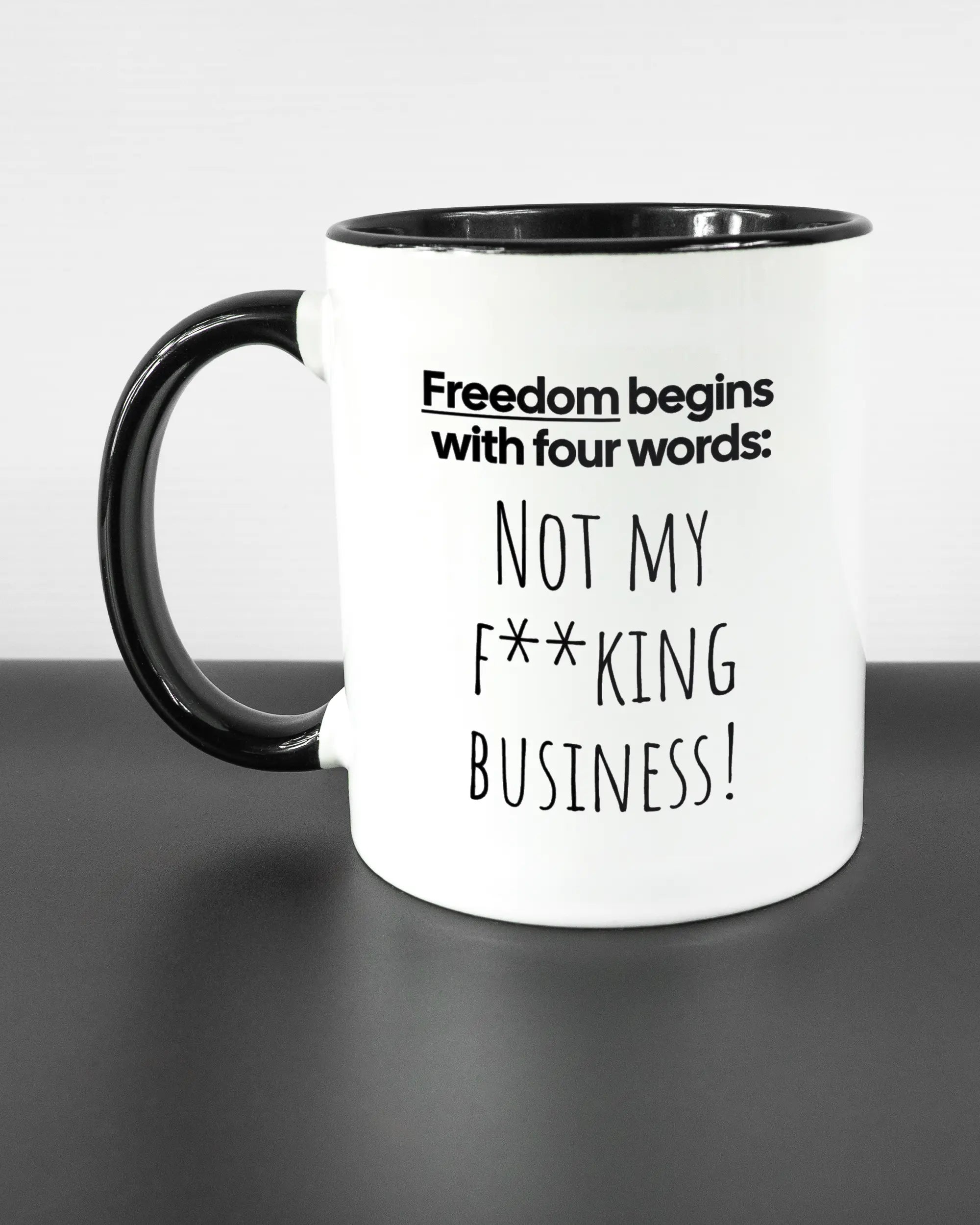 Titelbild, das die linke Seite der beidseitig bedruckten Keramiktasse von Maondo mit dem Design 4 Freedom in der Farbe Duotone auf einem Holztisch zeigt