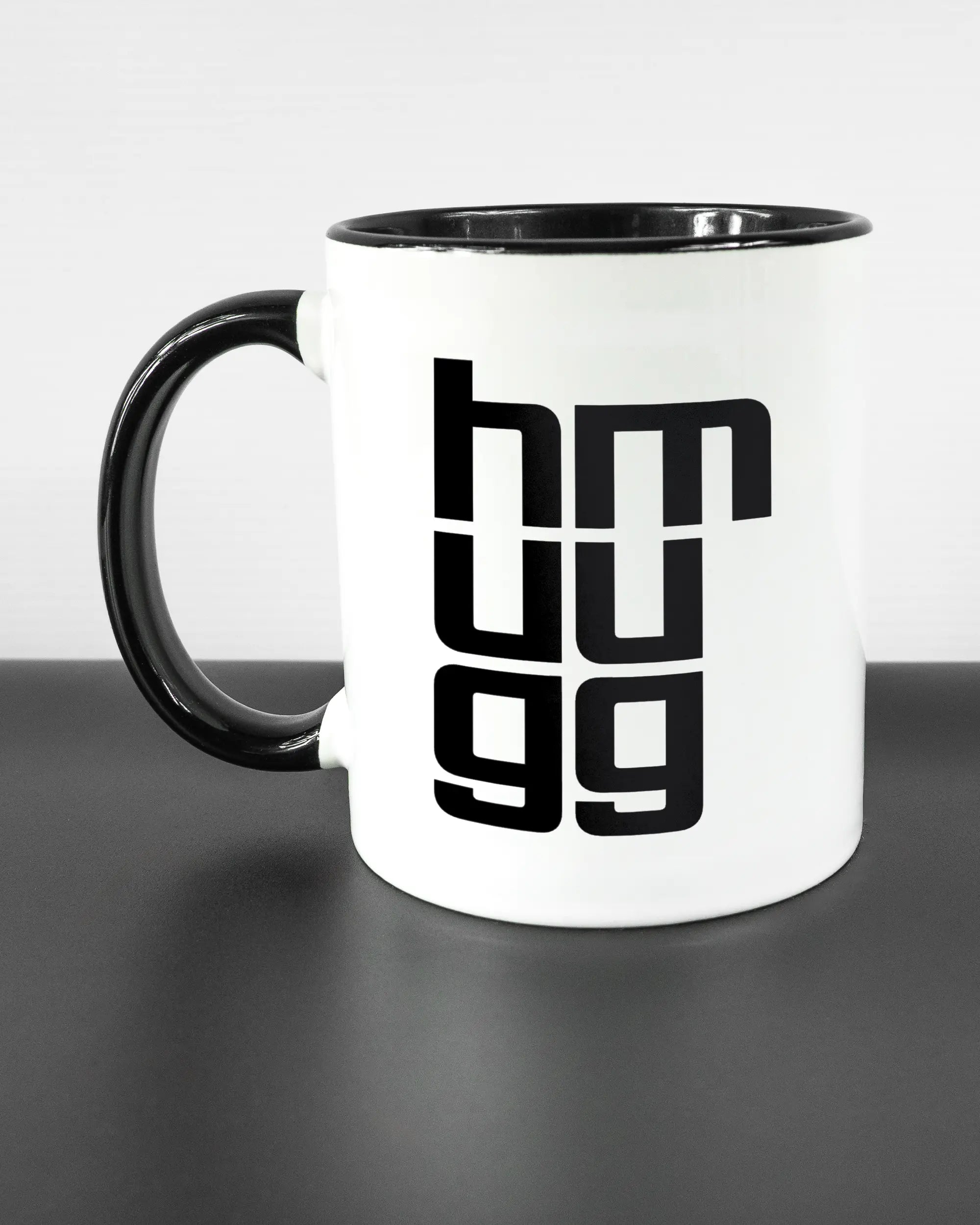 Titelbild, das die linke Seite der beidseitig bedruckten Keramiktasse von Maondo mit dem Design Hug Mug in der Farbe Duotone auf einem Holztisch zeigt